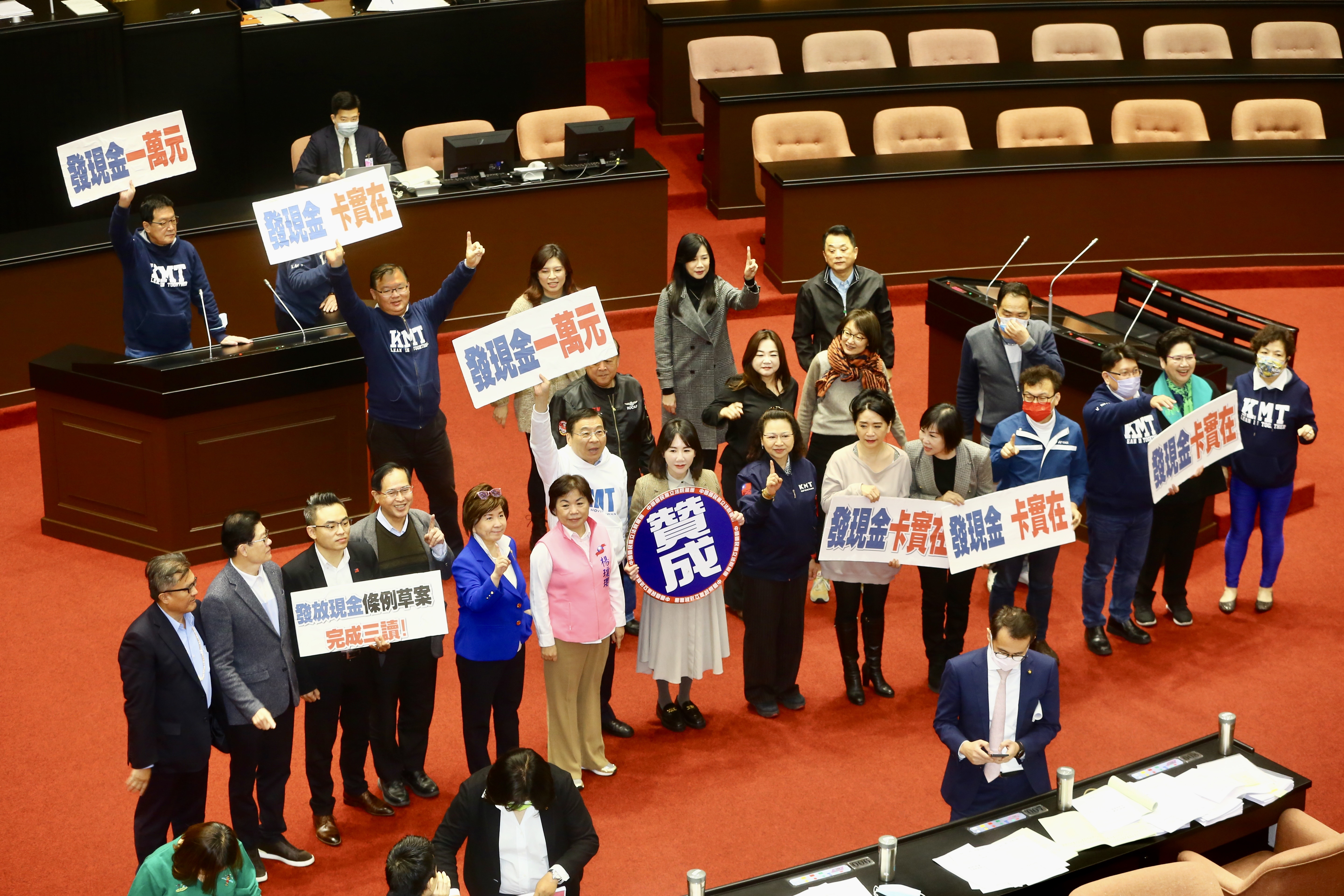 國民黨團高舉手板,甚至出現「發現金一萬元」字樣。