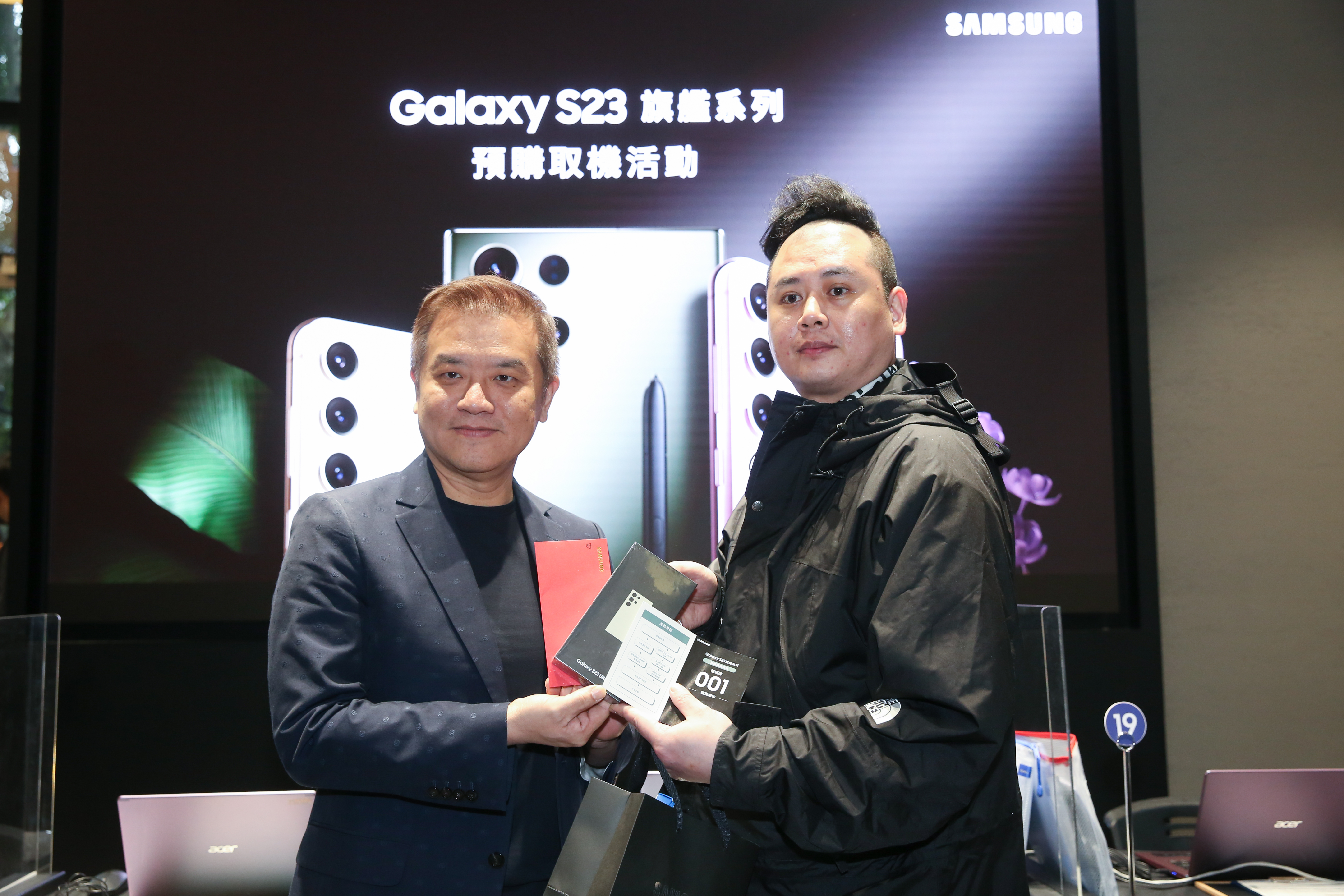 三星新一代旗艦機皇Galaxy S23系列新機在台舉辦預購優先取貨活動，搶頭香民眾透露5天前就到場等待。左為三星行動通訊事業部總經理陳啟蒙