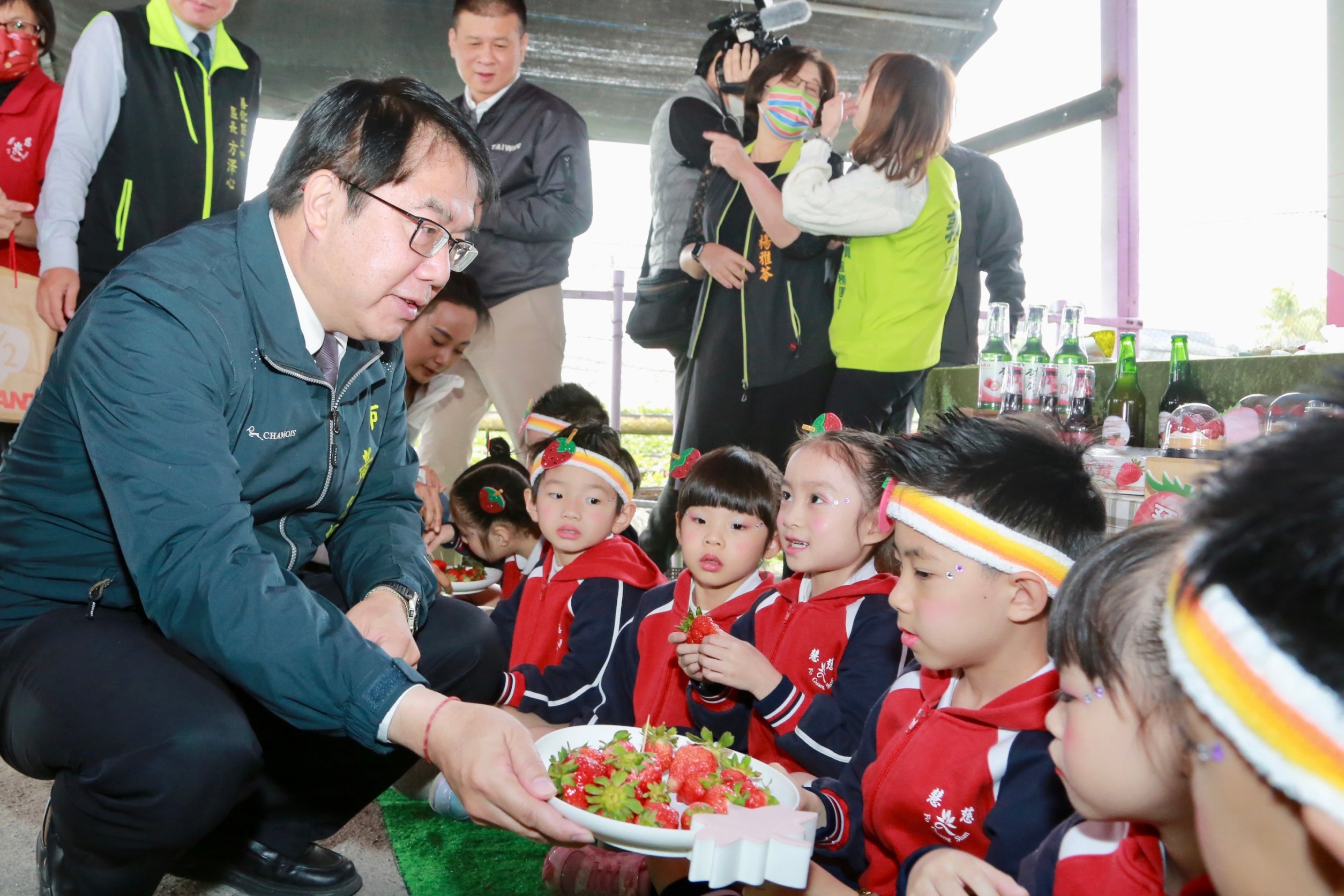 黃偉哲具親和力，出席行銷活動時拿起草莓讓小朋友開心吃到飽。（翻攝網路）