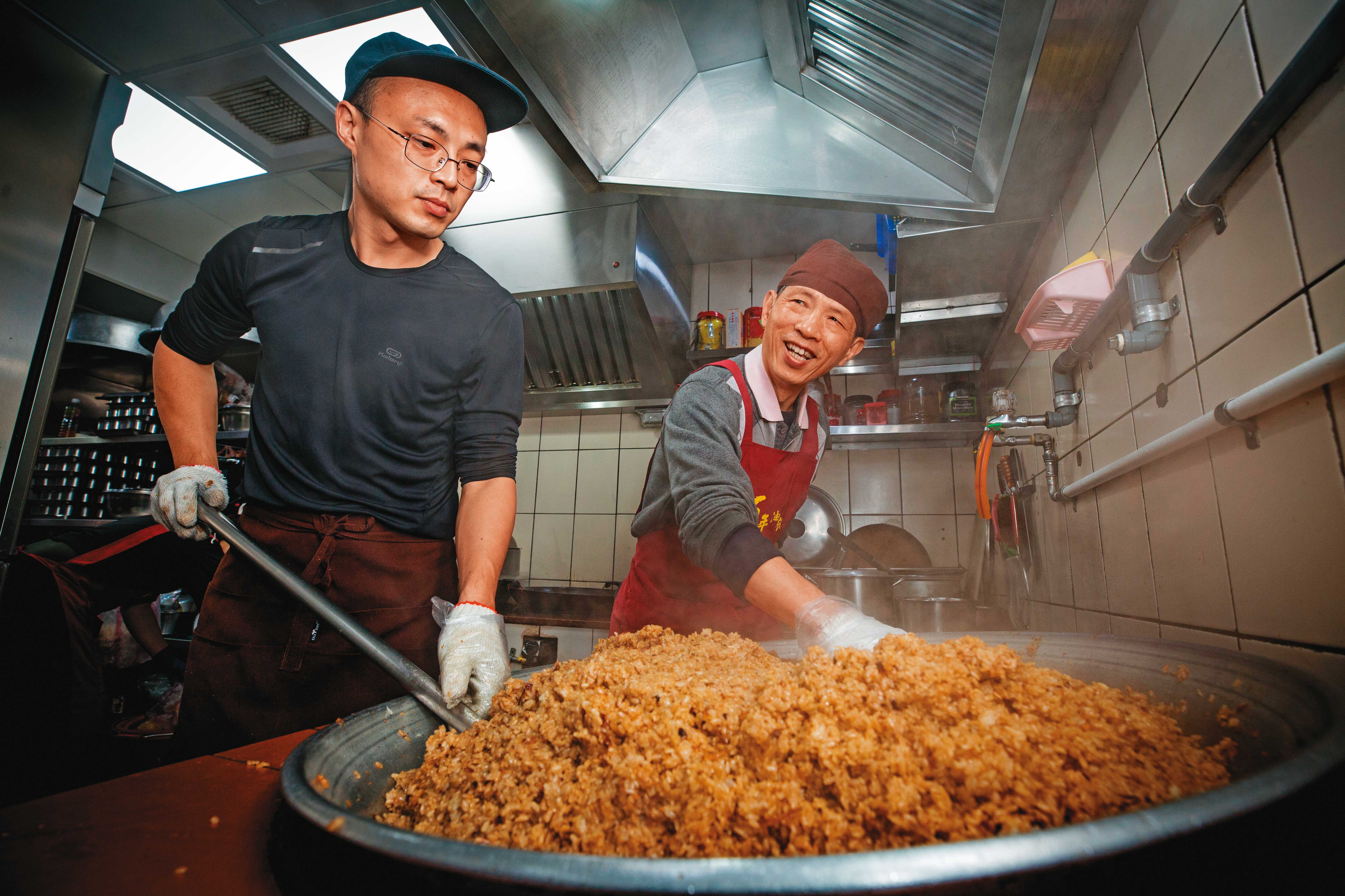 游記歷經老店歇業、第3代癌逝，第5代游世元（左）為多陪家人，辭去台積電工程師，返家與父親（右）合力炒香百年油飯。