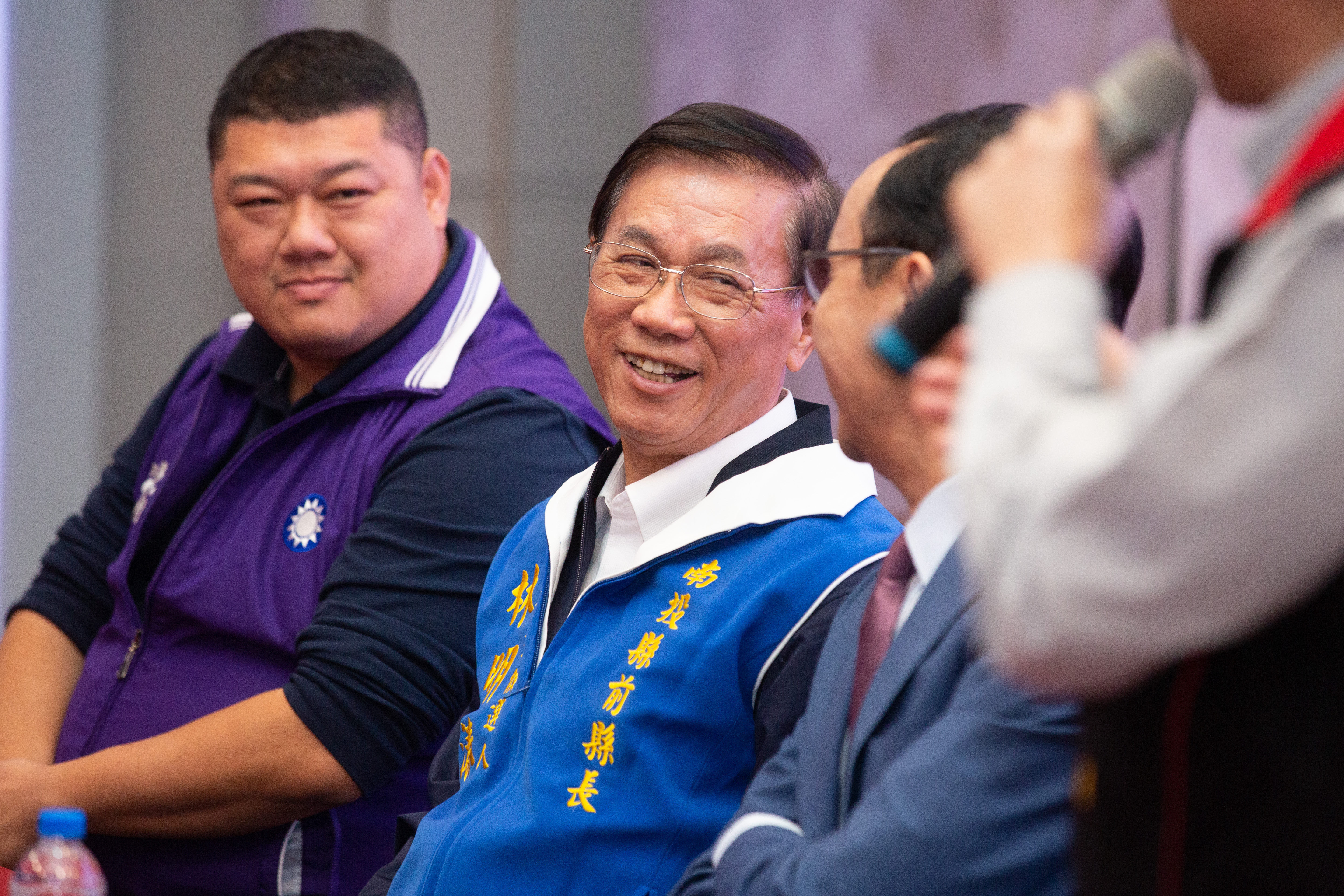 國民黨候選人林明溱（中）昨天搭車掃街時，遇到對手蔡培慧的人馬時，竟然比出倒讚手勢。（本刊資料照）