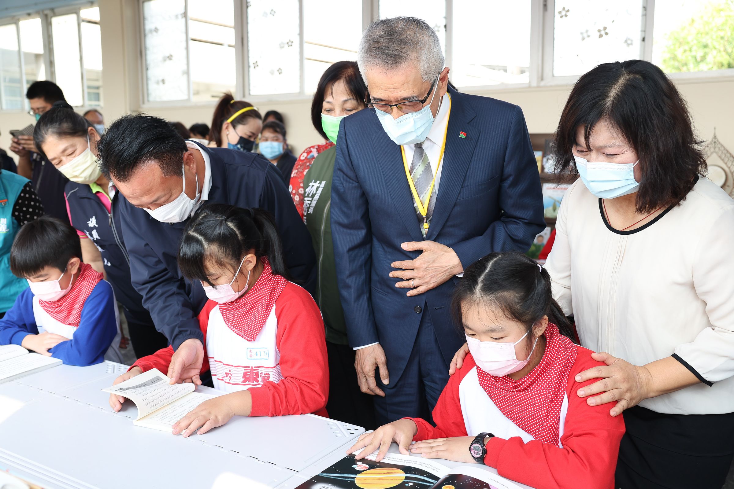 信義企業集團創辦人周俊吉陪同東榮國小學子在閱讀書軒看書，勉勵孩子透過閱讀改變人生。（信義房屋提供）