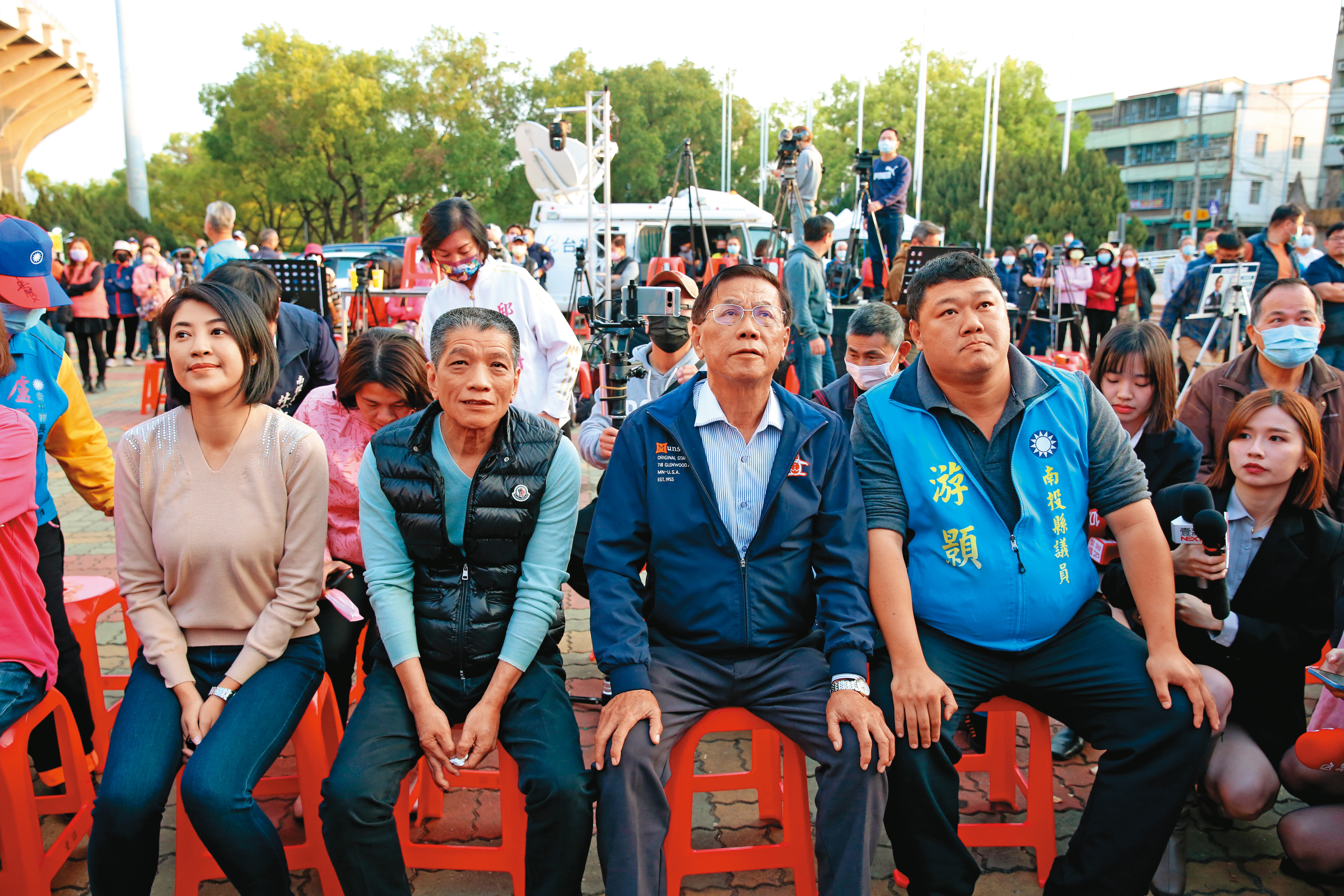 南投立委補選當天，林明溱（前右2）與藍營地方要角，神色凝重地看著開票。