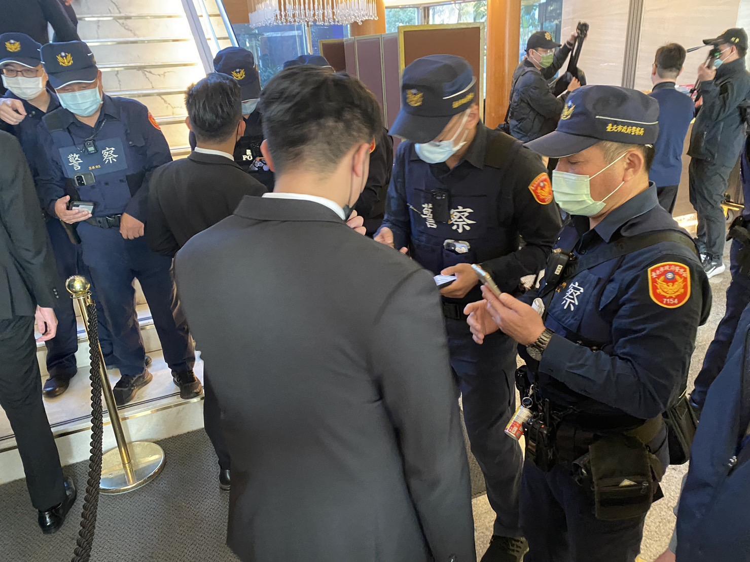 警方在飯店各出入口派駐警力，盤查與宴人士身分。（翻攝畫面）