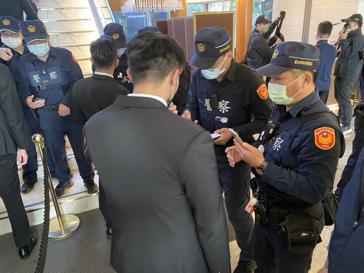 警方在飯店各出入口派駐警力,盤查與宴人士身分。(翻攝畫面)
