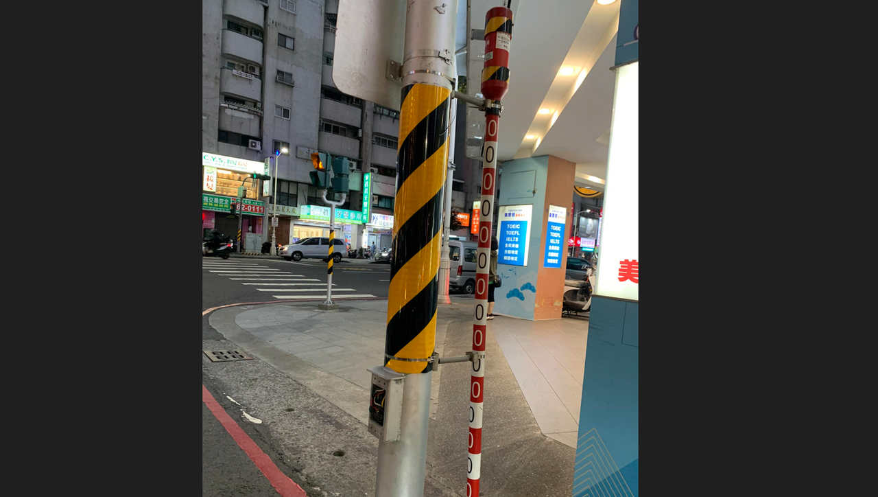 網友提醒若在電線桿旁邊看見這種紅白相間的細桿子,建議避開此處買房。(翻攝臉書社團「路上觀察學院」)