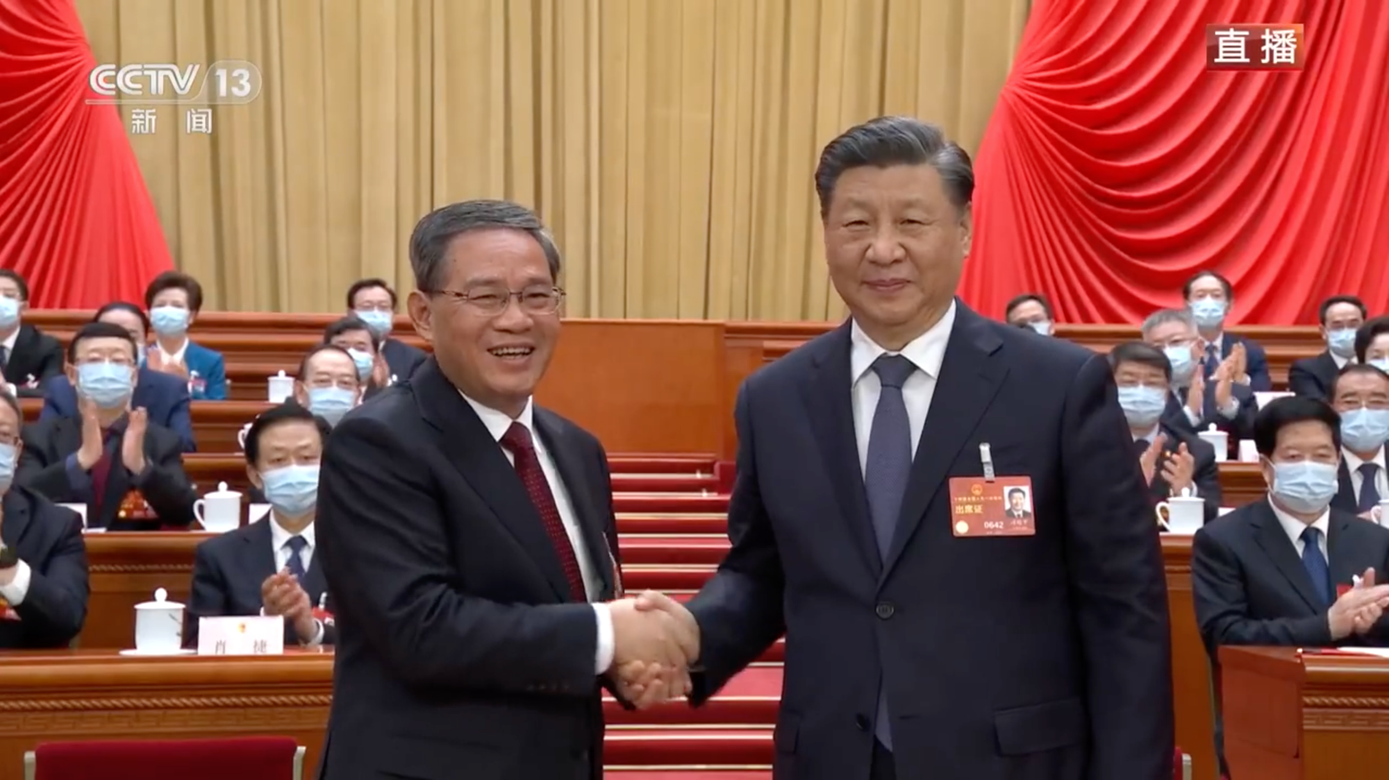 中國國務院總理由李強(左)接任,其在眾人掌聲下和習近平(右)握手。(翻攝自央視新聞)