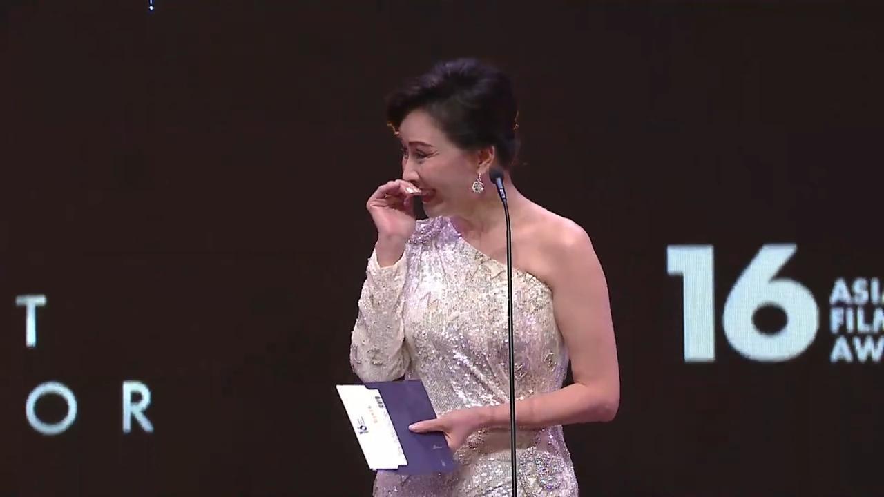 劉嘉玲擔任最佳男主角頒獎人,看到信封裡的名字時忍不住露出害羞微笑。(翻攝自轉播畫面)