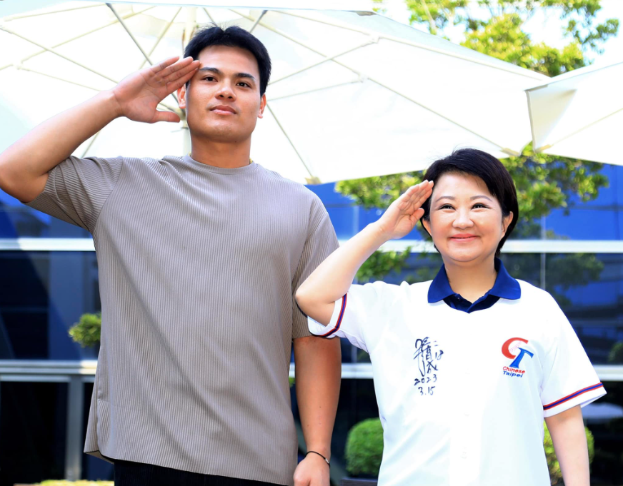 台中市政府昨替張育成舉辦舉辦祝福歡送會，市長盧秀燕比起張育成在球場上的招牌姿勢。（翻攝自盧秀燕臉書）