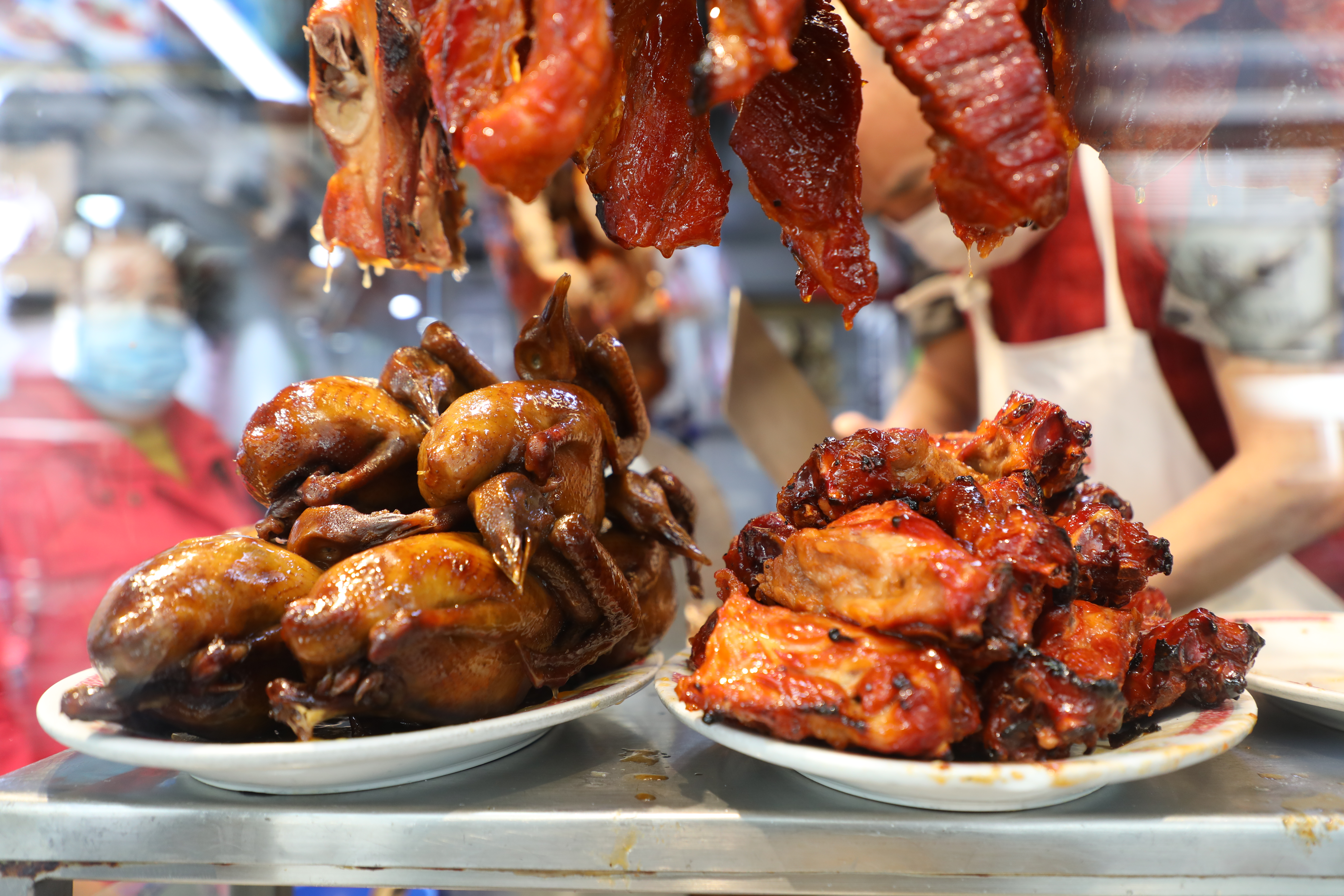 新園興記的燒味櫥窗裡展示著燒排骨和滷水乳鴿，令人垂涎。