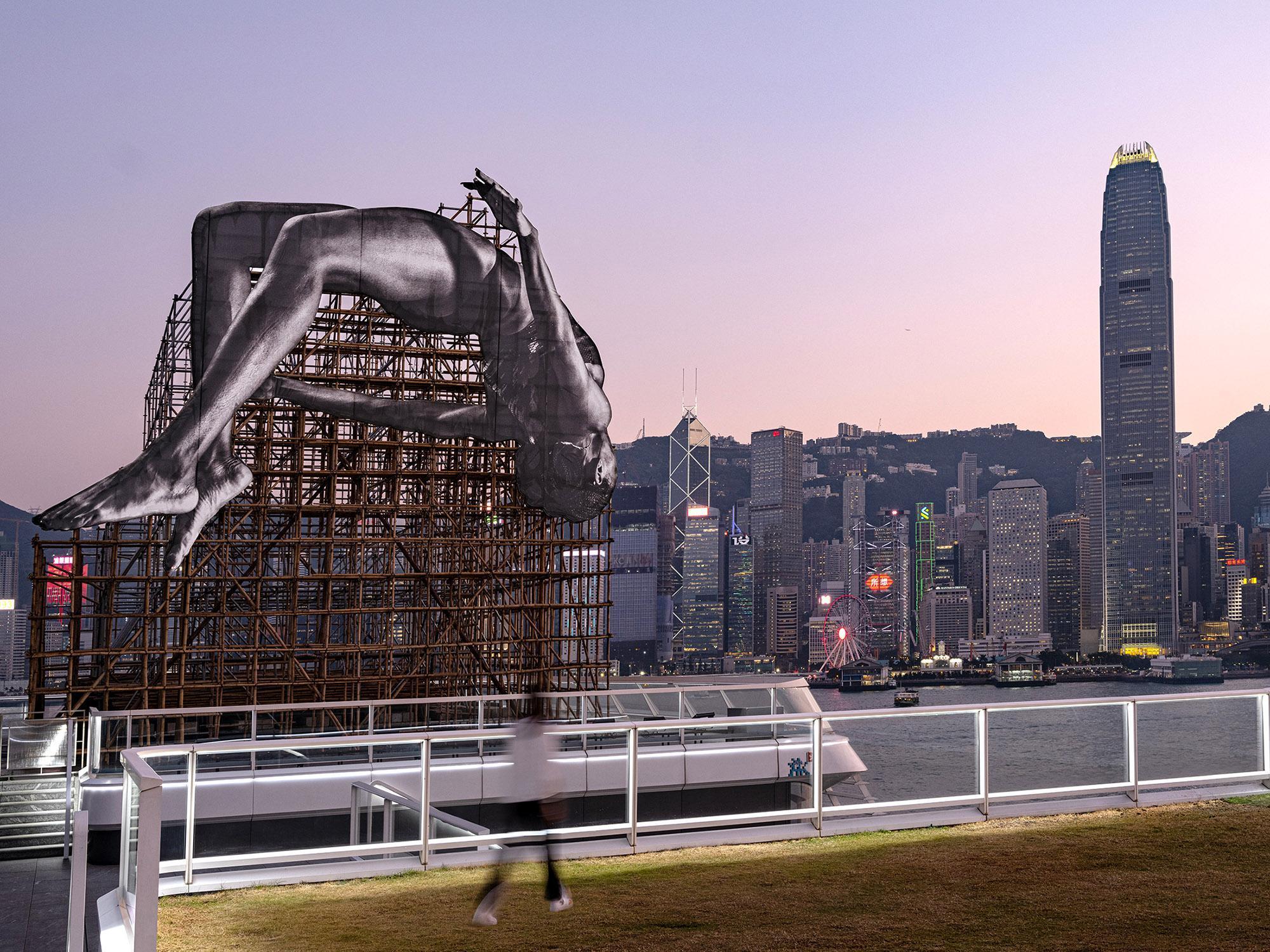 「GIANTS: Rising Up」以JR一貫的黑白風格呈現,首次加入香港建築工地中常見的「竹製腳手架」。(海港城提供)