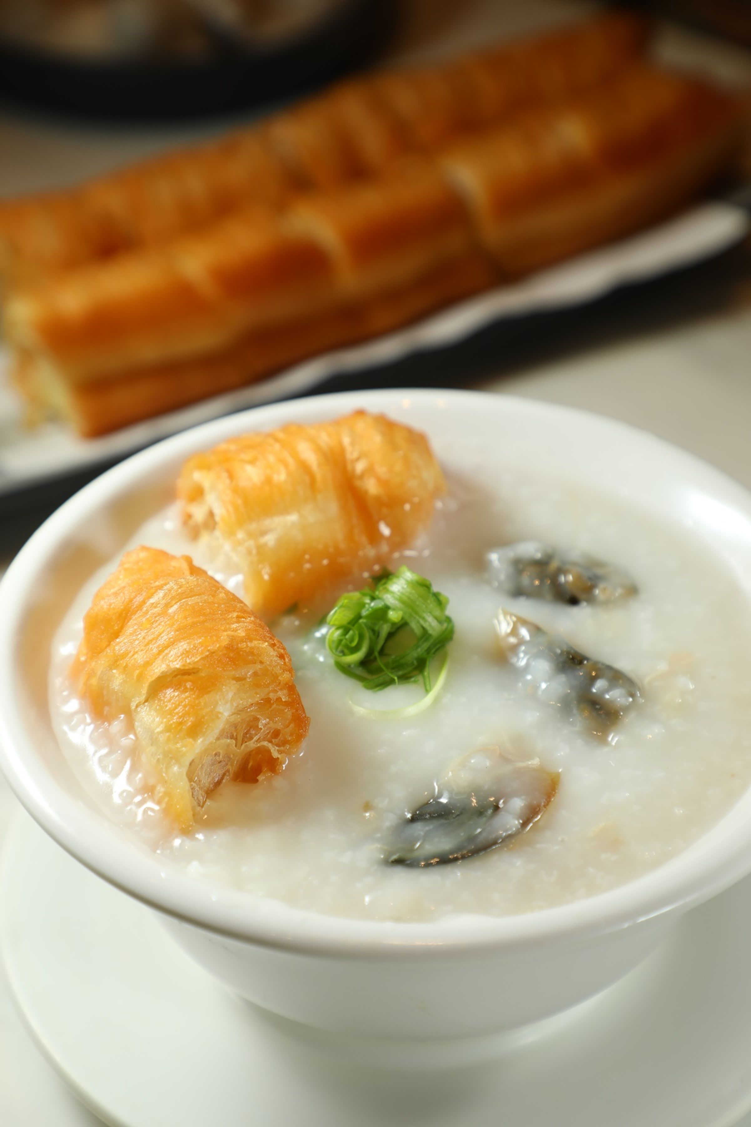 靠得住的「皮蛋瘦肉粥」(右,港幣46元/碗)清爽有味,與「鮮炸油條」(左,港幣28元/份)搭配相得益彰。