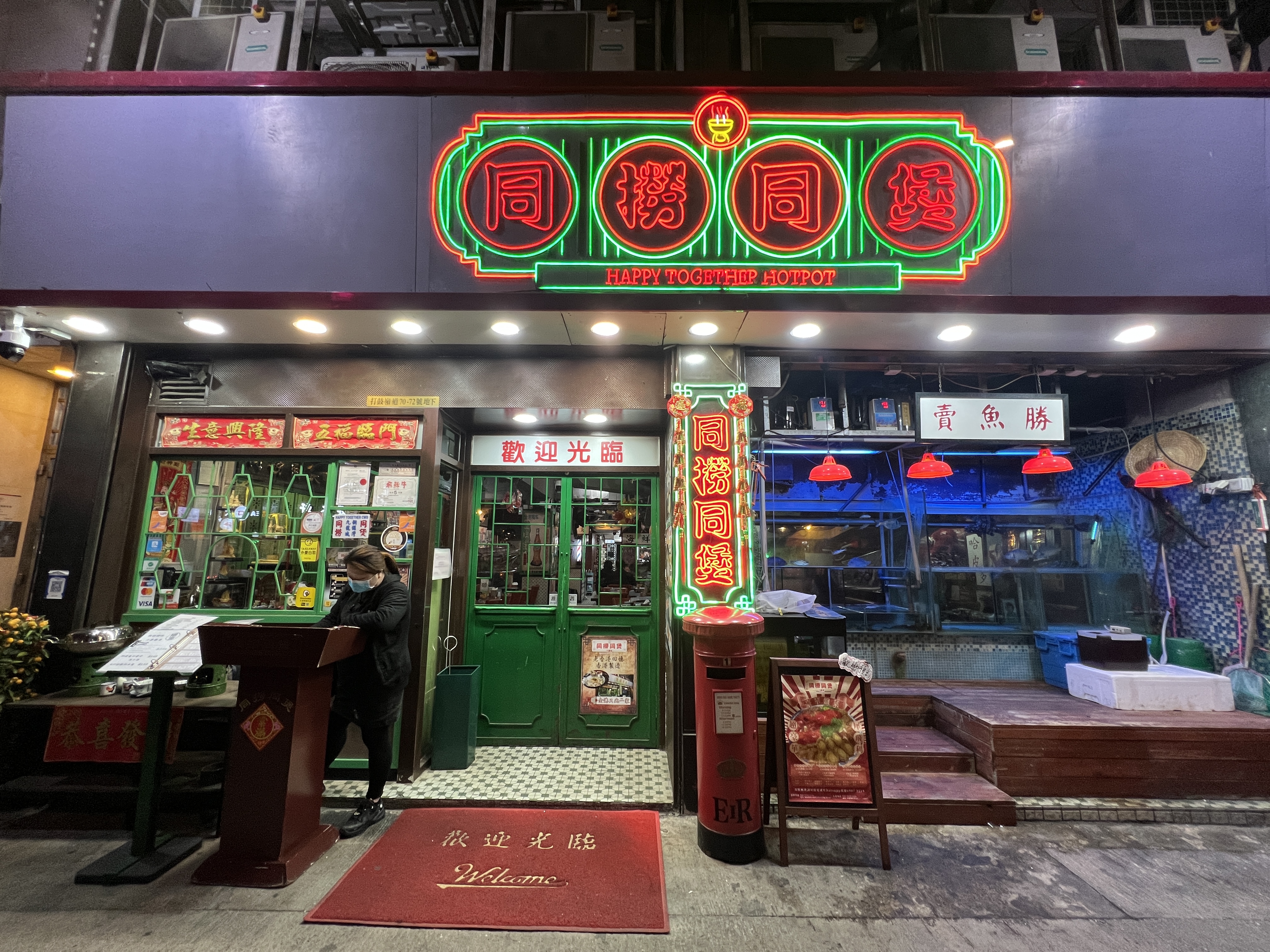 以霓虹燈管裝飾的門面，凸顯「同撈同煲火鍋」的懷舊香港主題。