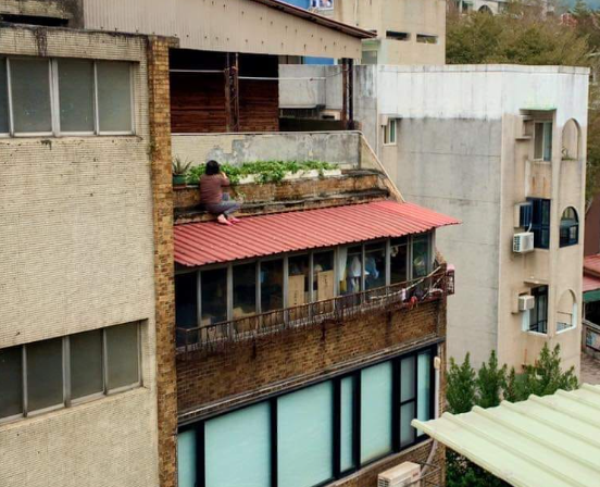 有網友拍下一名阿嬤蹲在屋頂種菜，讓旁人看了心驚驚。（翻攝自路上觀察學院）