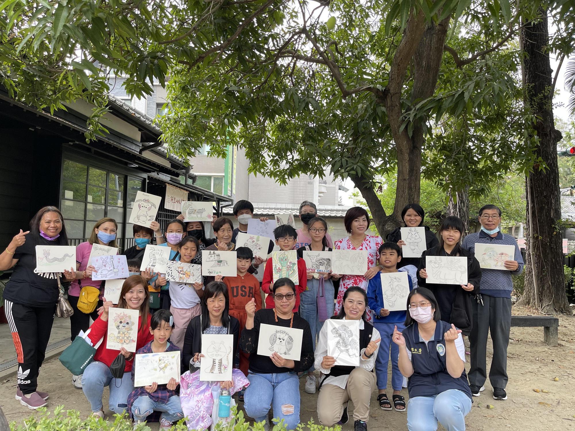 參與的新住民家庭開心地拿著作品與講師申婷頡(前排右二)合影。(移民署提供)