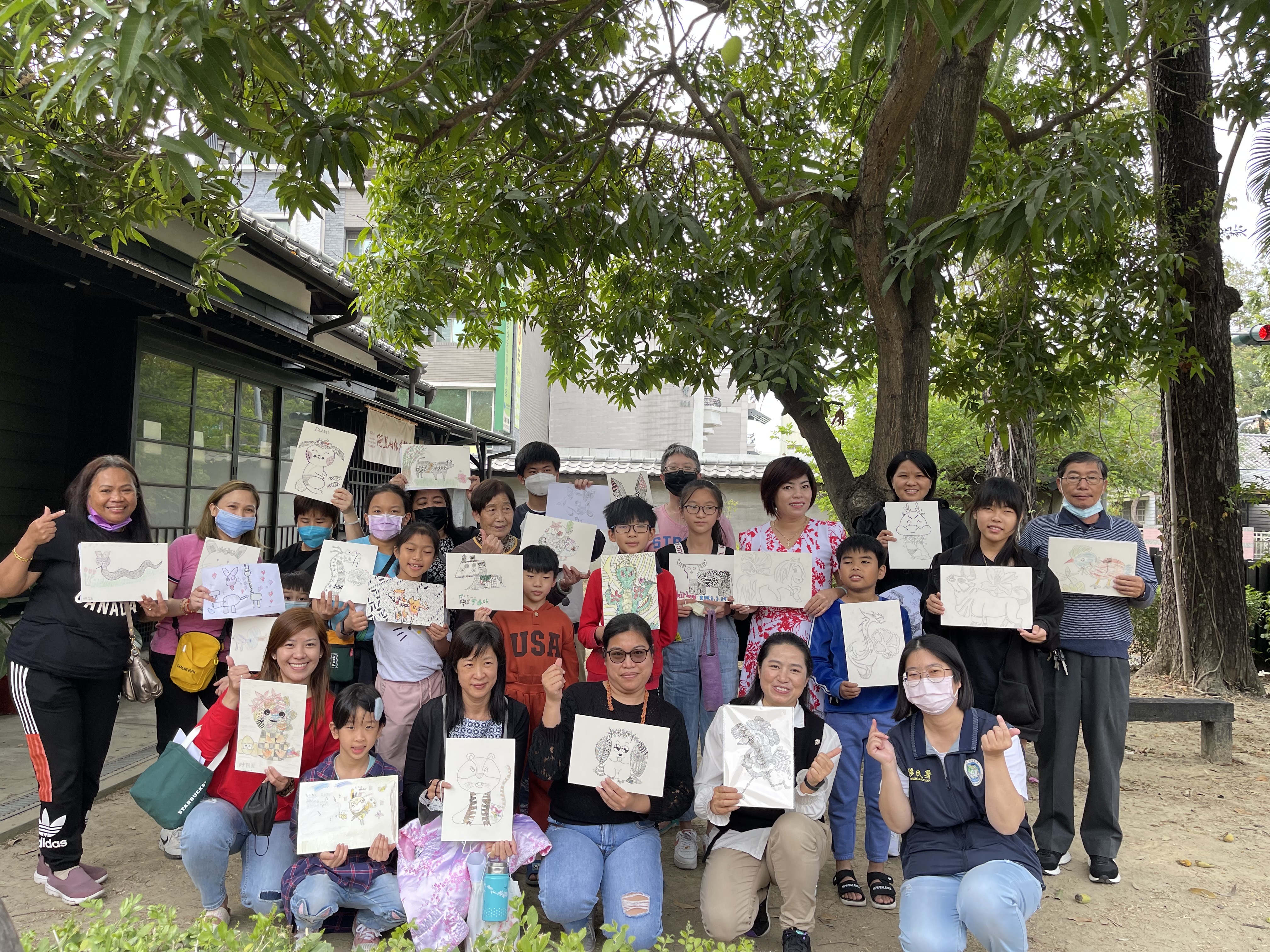 參與的新住民家庭開心地拿著作品與講師申婷頡（前排右二）合影。（移民署提供）