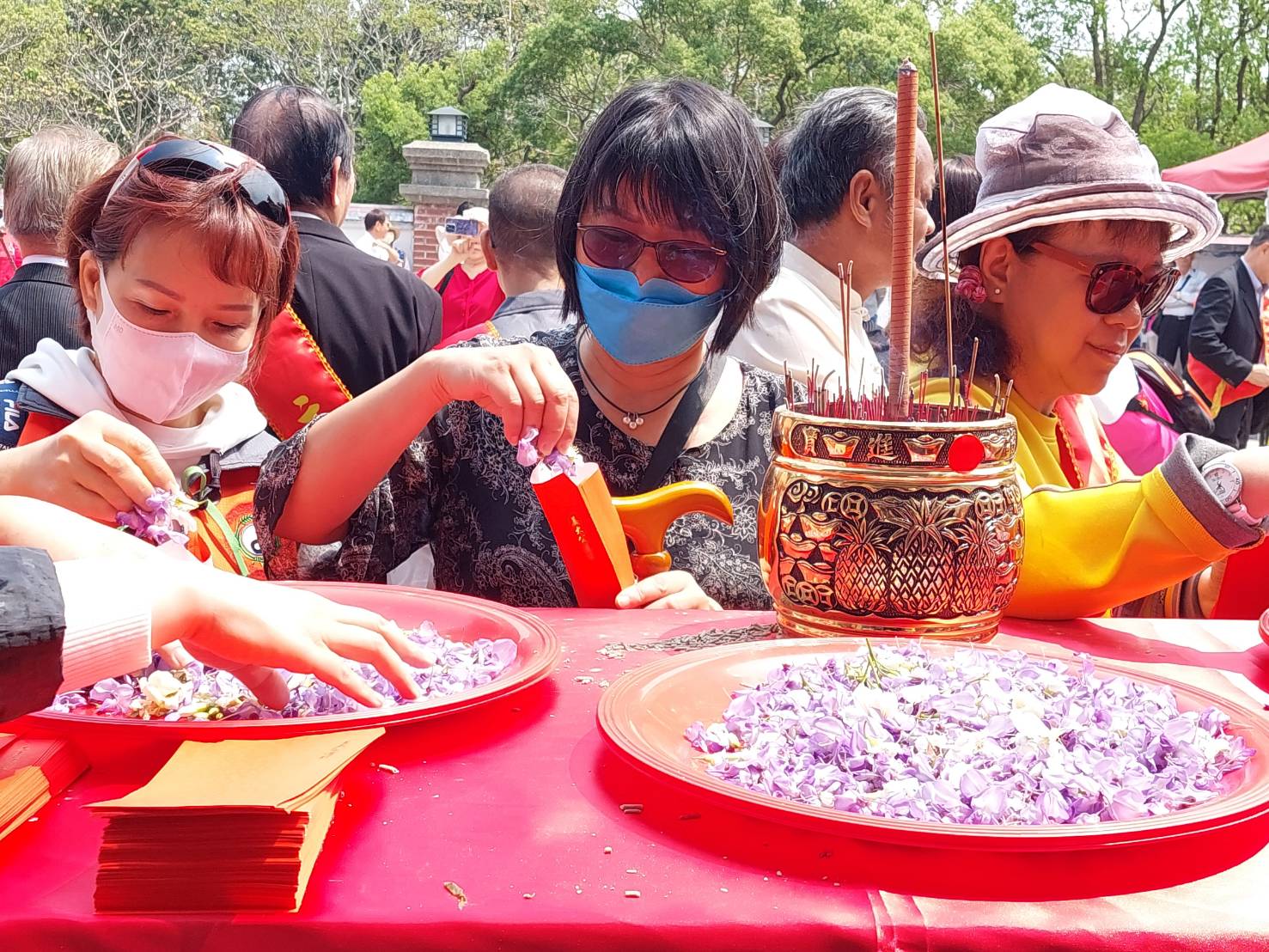 民眾爭相取用法師加持過的桐花，帶回家洗浴淨身。（姜太公道場客家大院提供）