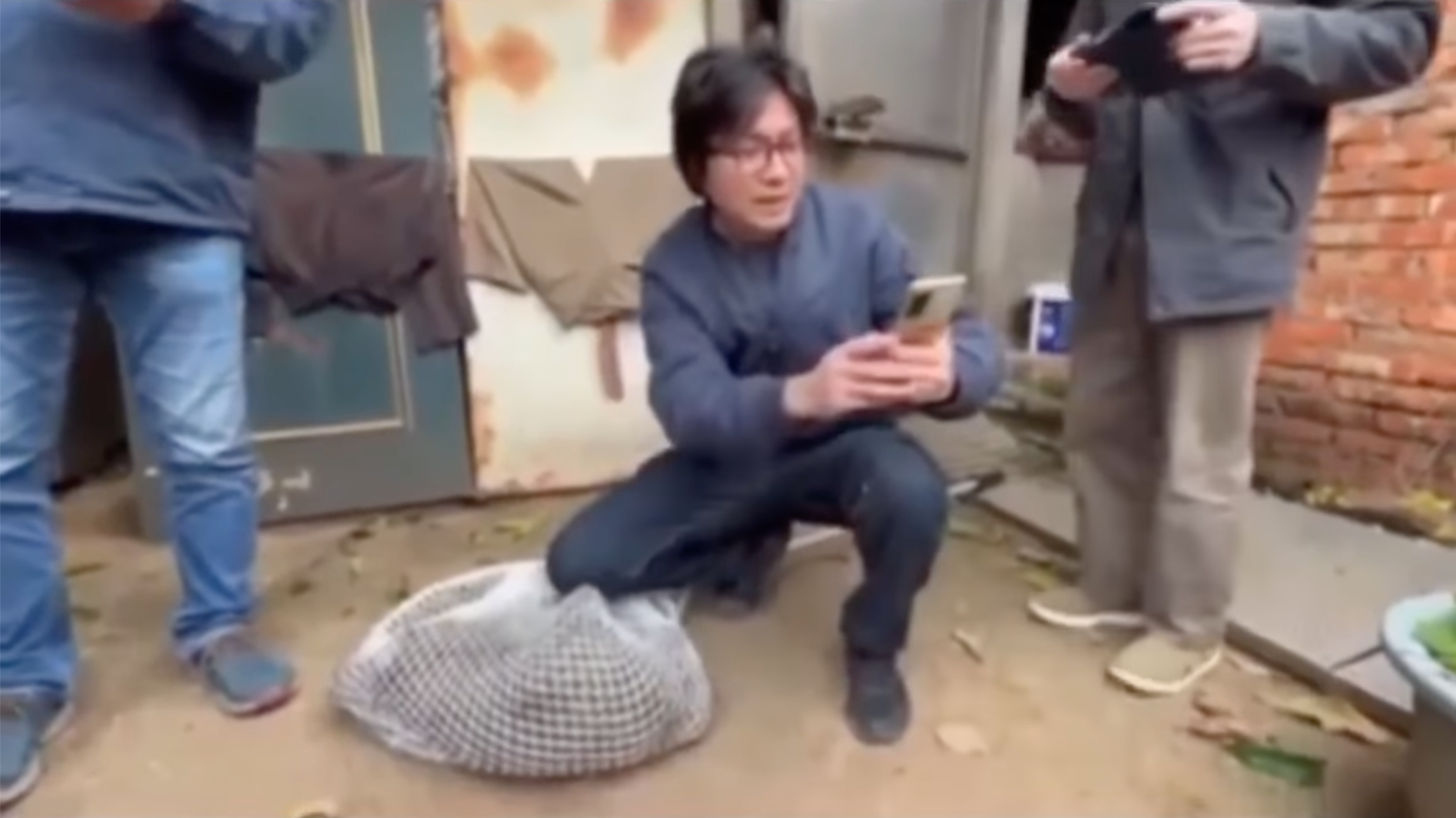 桃市農業局專委盧紀燁等人在捕獲現場與傷重的狒狒開心合影，如今看起來相當諷刺。（翻攝畫面）