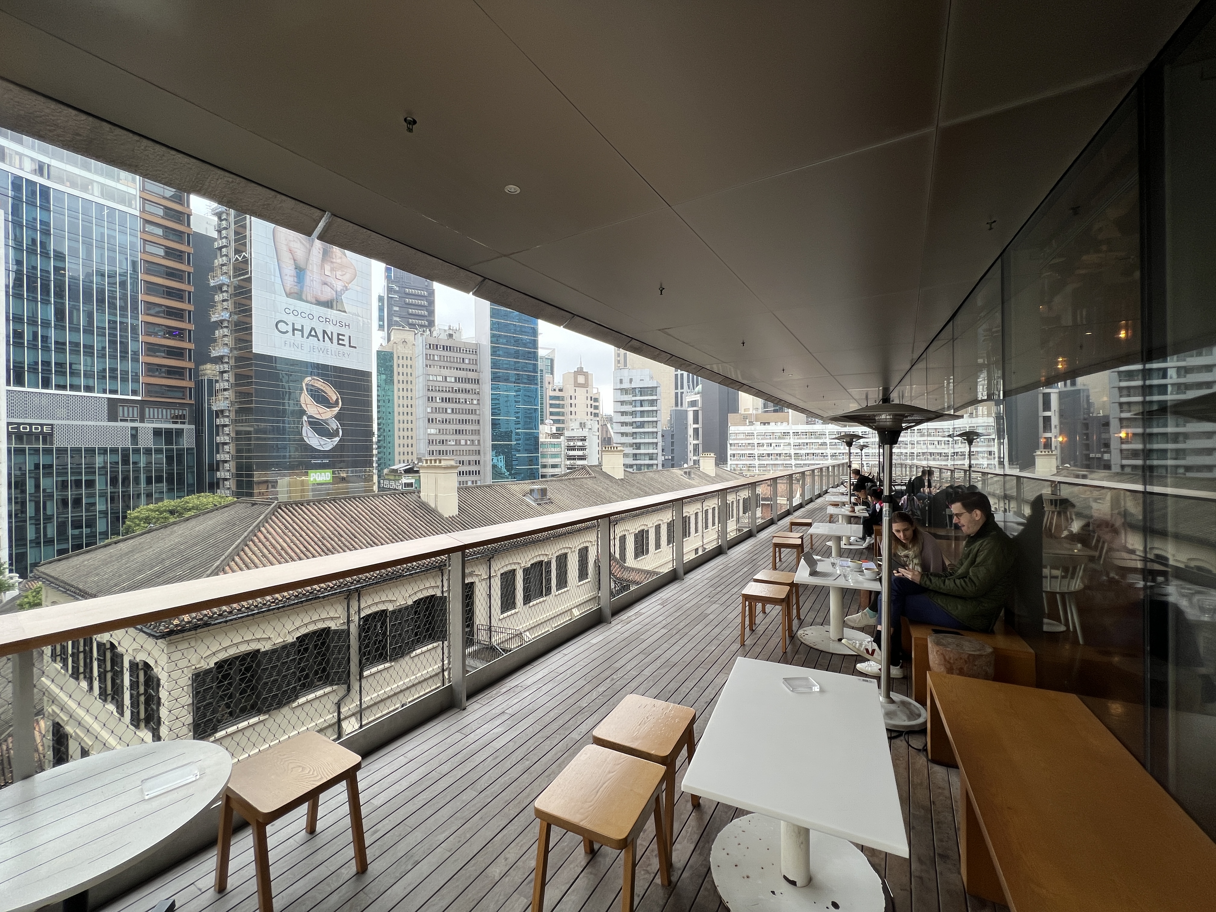 「Between Coffee」的戶外位置正對著沐浴樓的屋頂以及中環的摩天大樓。
