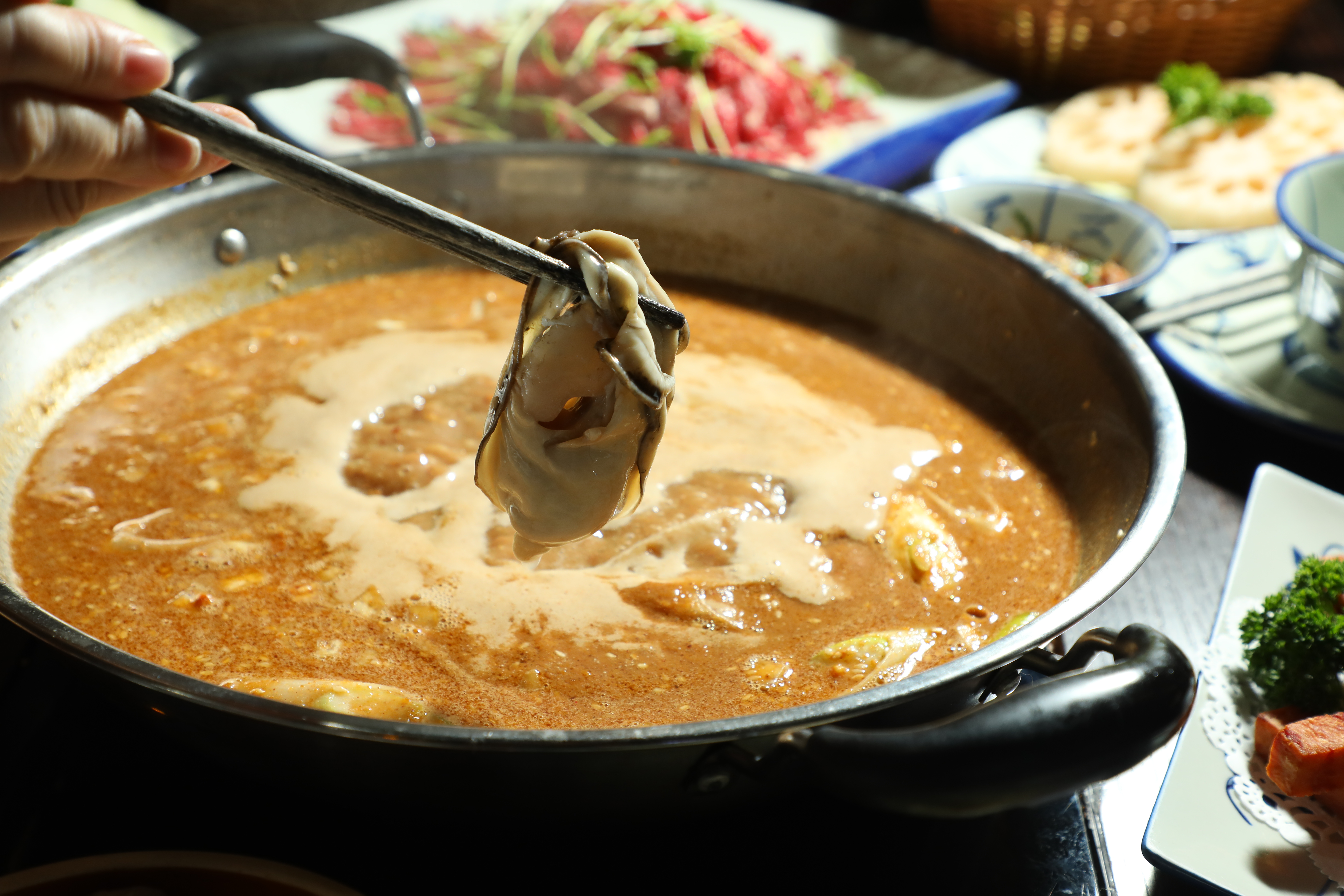 將「美國桶蠔」（港幣198元／份，約 NT$777）放入「老港沙嗲鍋」（港幣148元／份，約 NT$580）中，吸滿特濃湯汁後豪氣吃下肚。