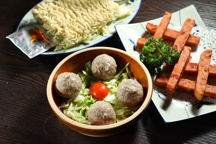 「爆漿瀨尿牛丸」（前，港幣78元／份，約NT$306）、「煎午餐肉」(右，港幣58元／份，約NT$228）與「出前一丁」（後，港幣22元／份，約NT$86），都是經典火鍋料。