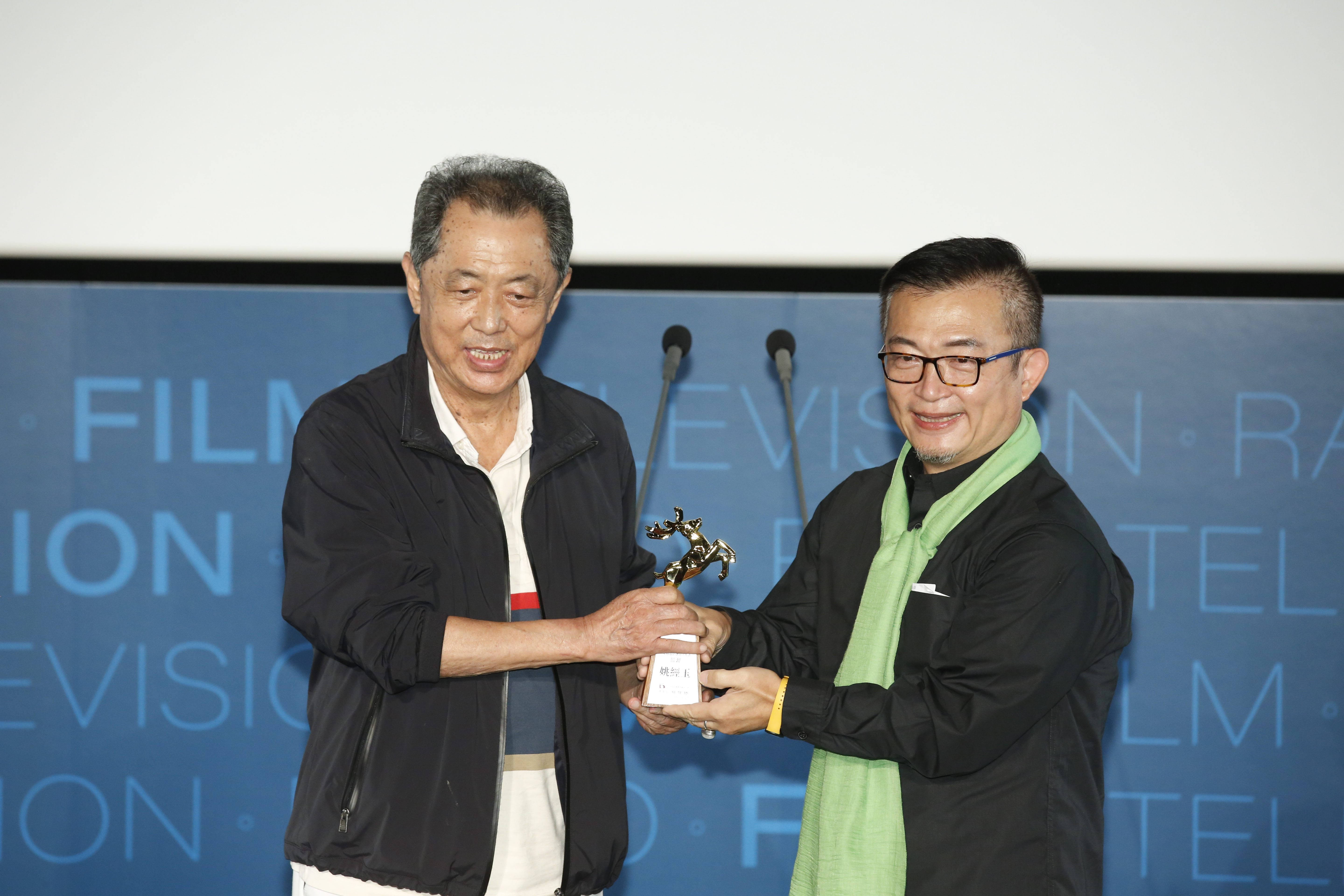 朱延平導演將「年度傑出影視工作者」頒給海鵬影業總監姚經玉。