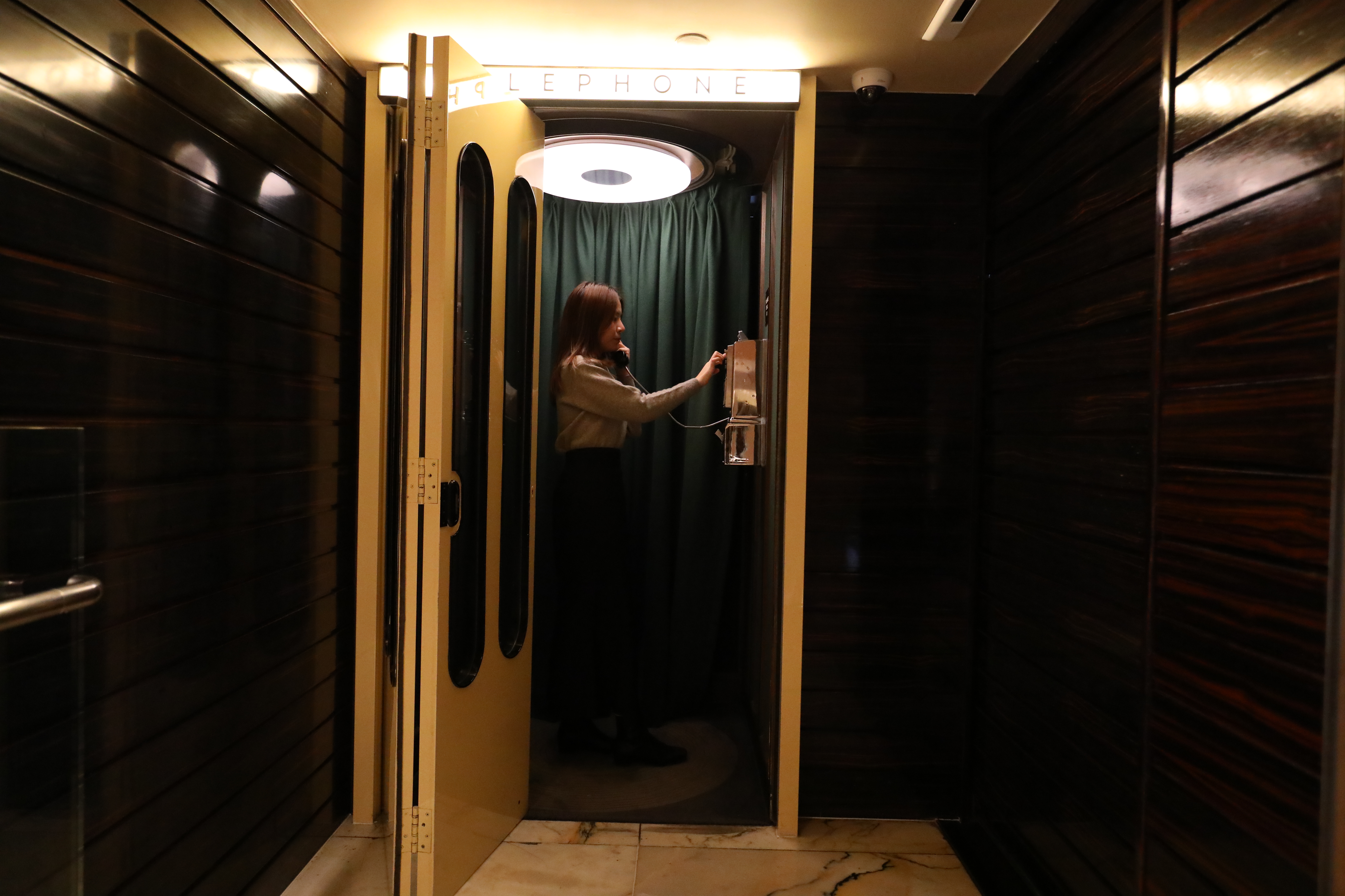 誰能想到在手機社會，還要打公用電話才能進門？