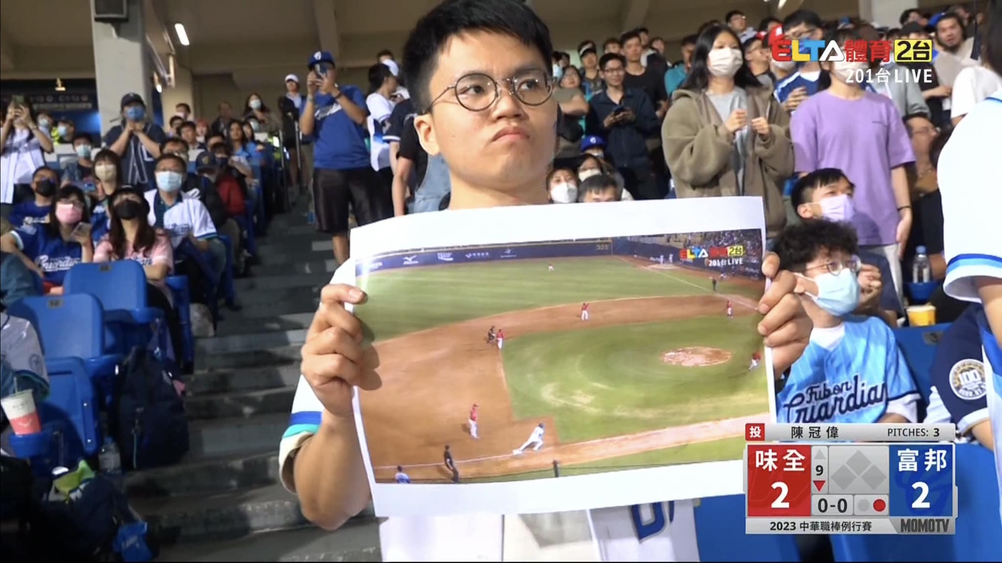 一名男球迷在觀眾席高舉轉播畫面證明王正棠沒有偷跑，畫面曝光引起熱烈討論。（翻攝自愛爾達體育家族臉書）