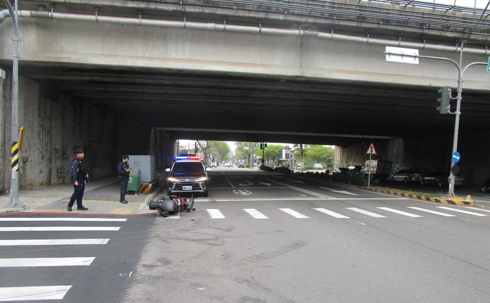 王姓騎士經過台中市西屯區國道一號橋下時，撞擊一鐵質物品導致車輛翻轉慘摔。（翻攝畫面）