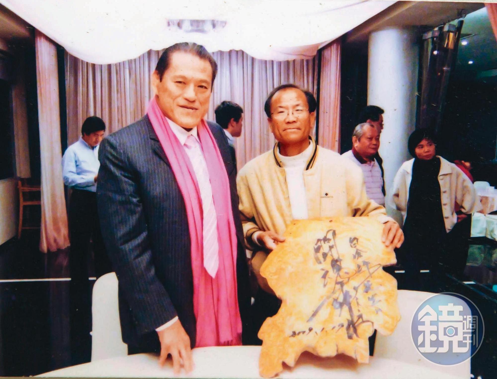 白滄沂（右）的作品常被政府機構用以贈送國際友人，日本摔角好手豬木（左）回贈親筆題字。（白滄沂提供）