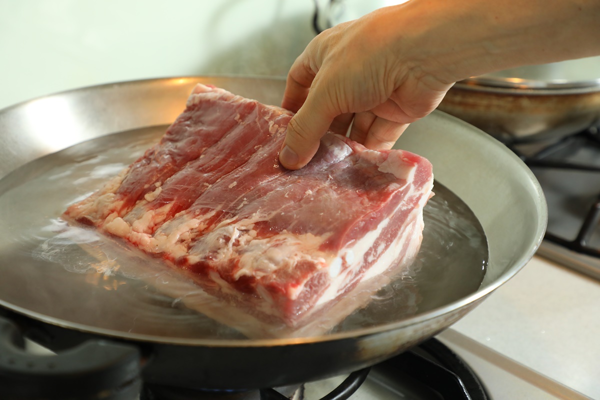 將七層肉放入熱水中。