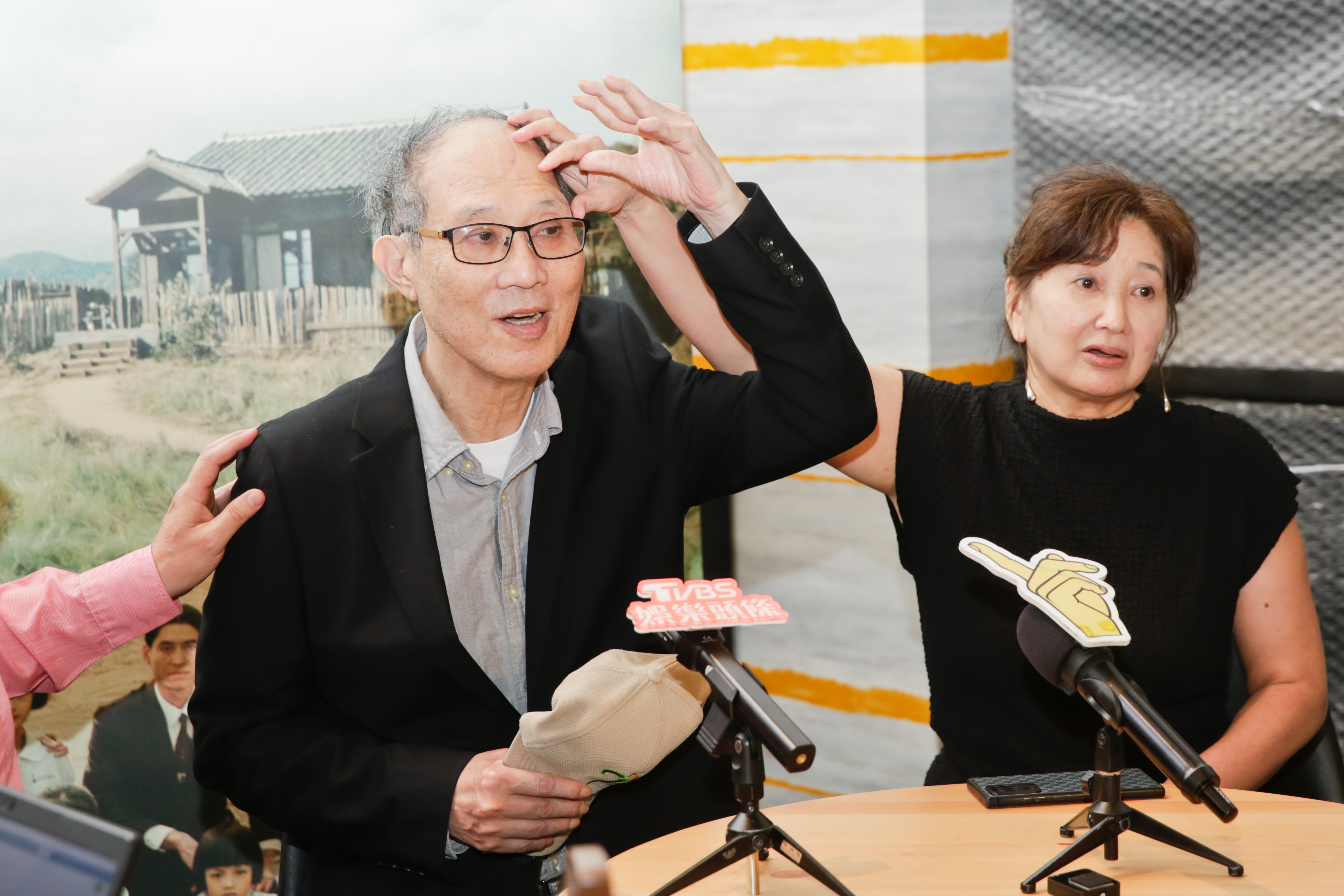 萬仁(左)1年多前泡溫泉時不慎跌倒受重傷,頭蓋骨碎裂,他脫下帽子秀出頭頂,外觀看來與一般人無異,但透露其實材質是鈦合金。