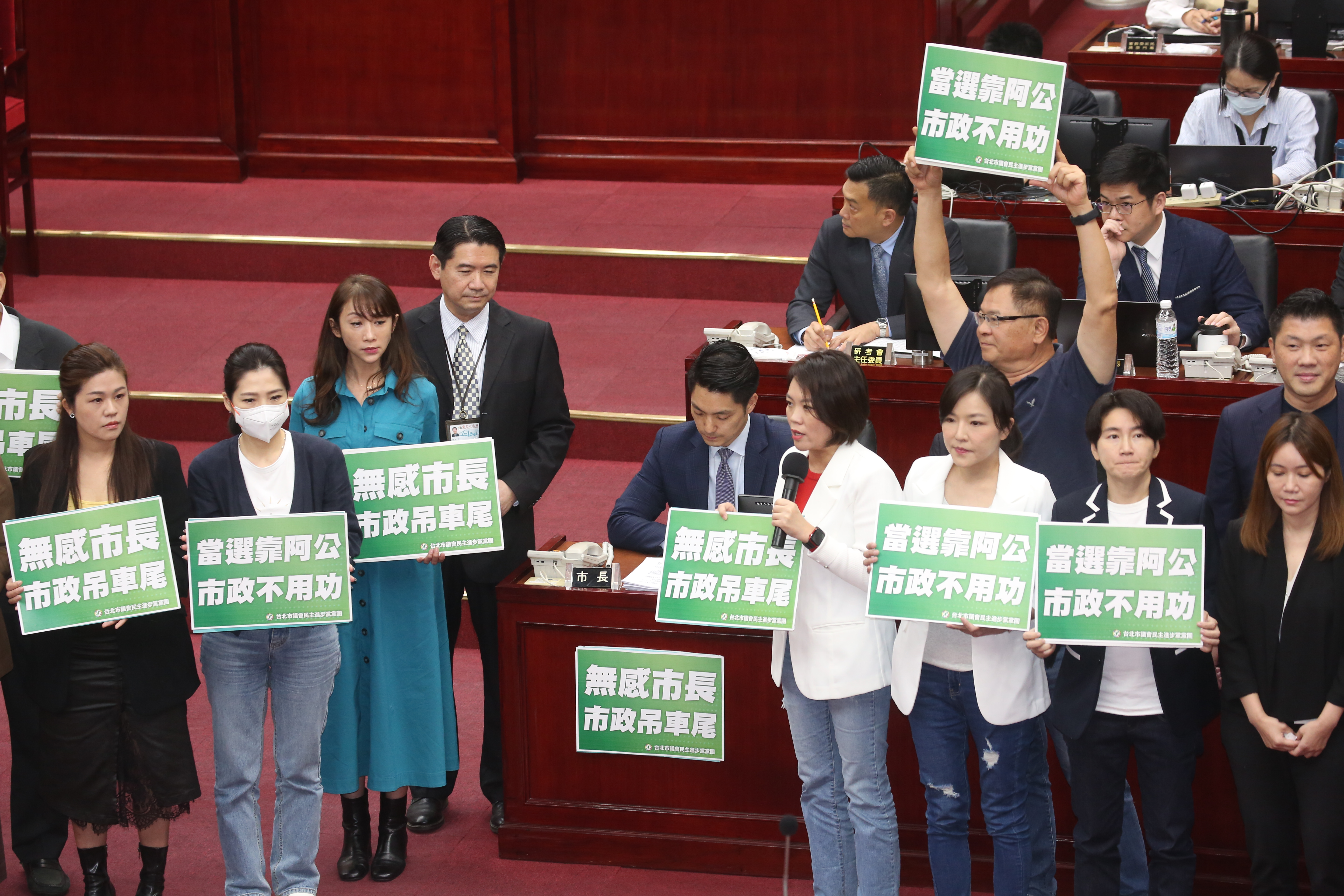 民進黨團在蔣萬安身旁舉牌，批其當選靠阿公、無感市長等。