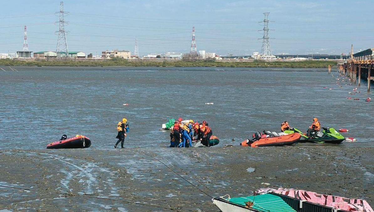 海巡人員在海岸邊打撈偷渡客浮屍。(海巡署提供)