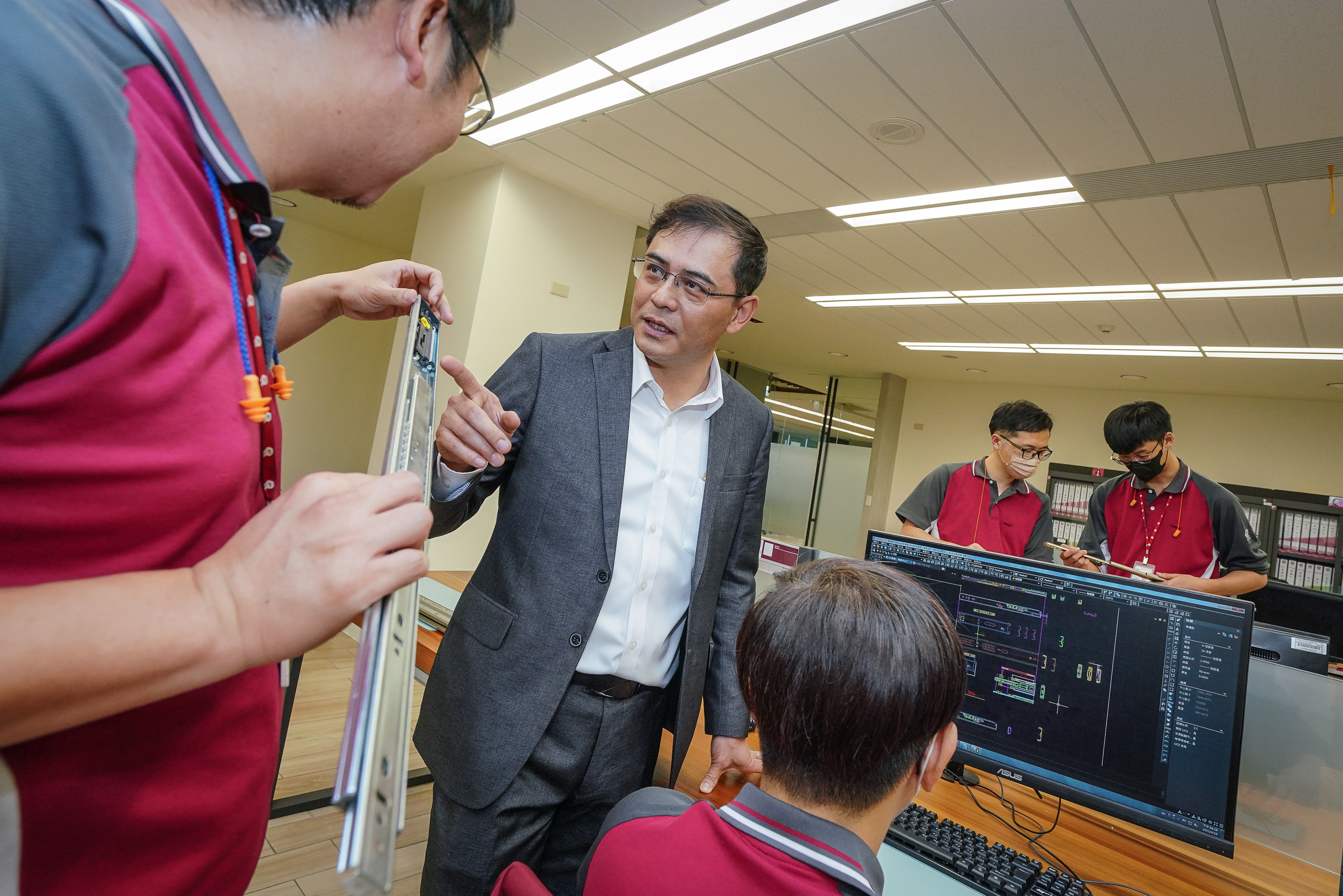 吳仁山（左2）擅於觀察客人需求，時常與研發工程師開會調整設計。