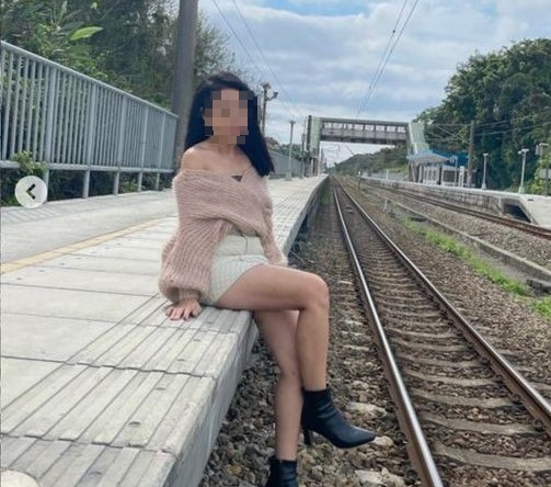 女主播跨坐在月台，雙腳放在軌道上方，此行為已違規觸法。（翻攝自台灣便當管理局-附屬鐵路部臉書）