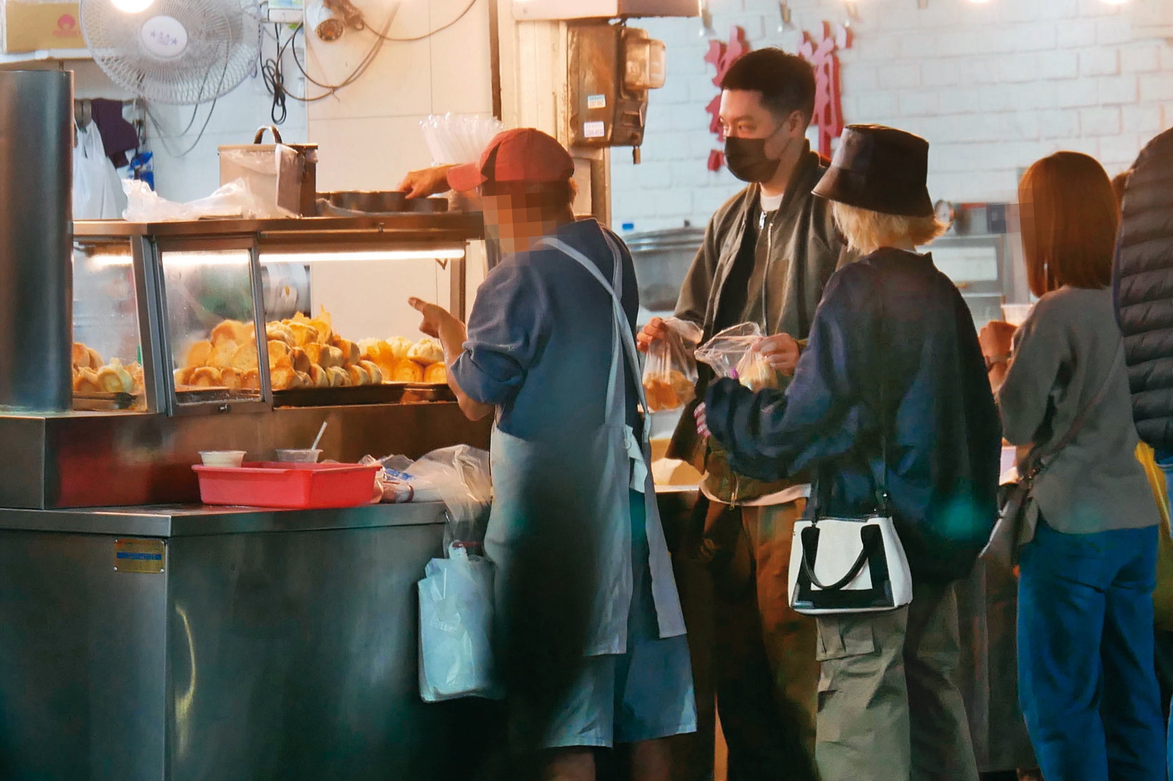 4月2日 20：19 兩人排隊買了煎包，離開時周湯豪（左二）與鄭雲燦（左三）似乎發現被跟拍，之後草草結束約會。