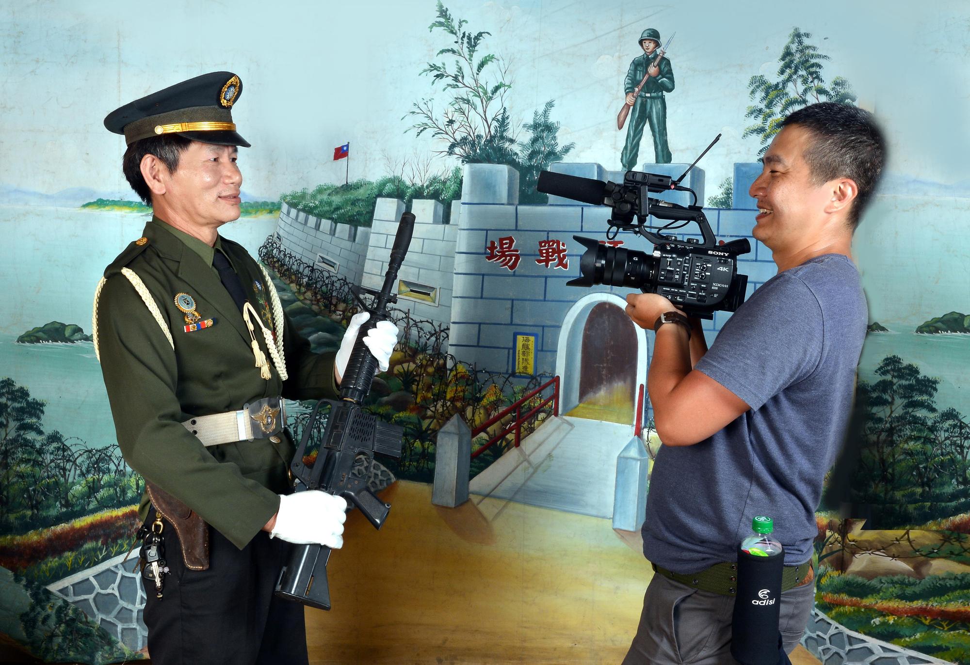 導演洪淳修（右）與穿上軍裝拍照的便當店老闆黃善勇（左）。（紅潤影像提供）