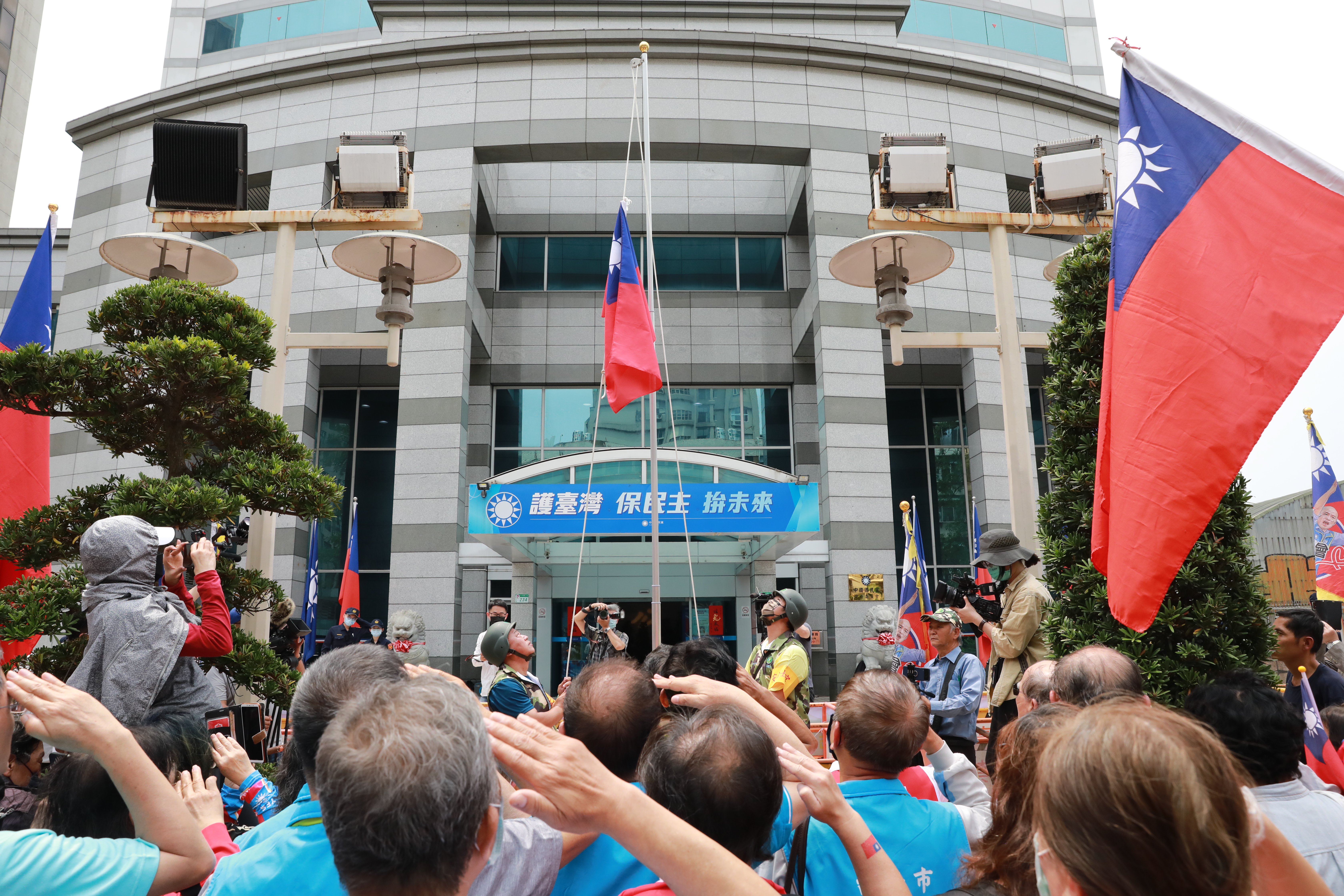 韓粉們在國民黨中央黨部前升旗、唱國歌。