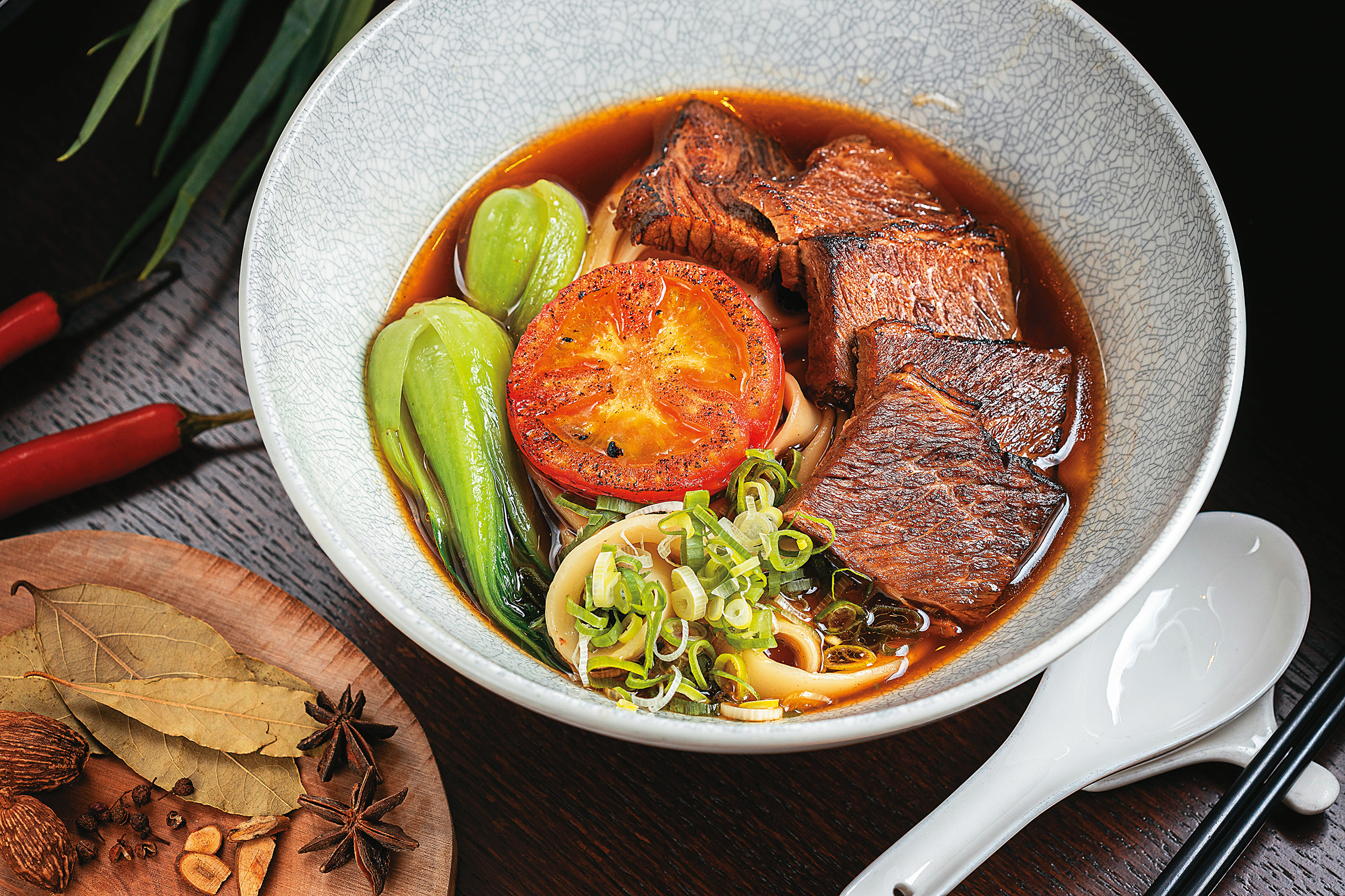 「萬豪牛肉麵」的湯頭加入老母雞熬煮48小時，並淋上特製辣味牛油，濃郁黏嘴。（660元／碗）