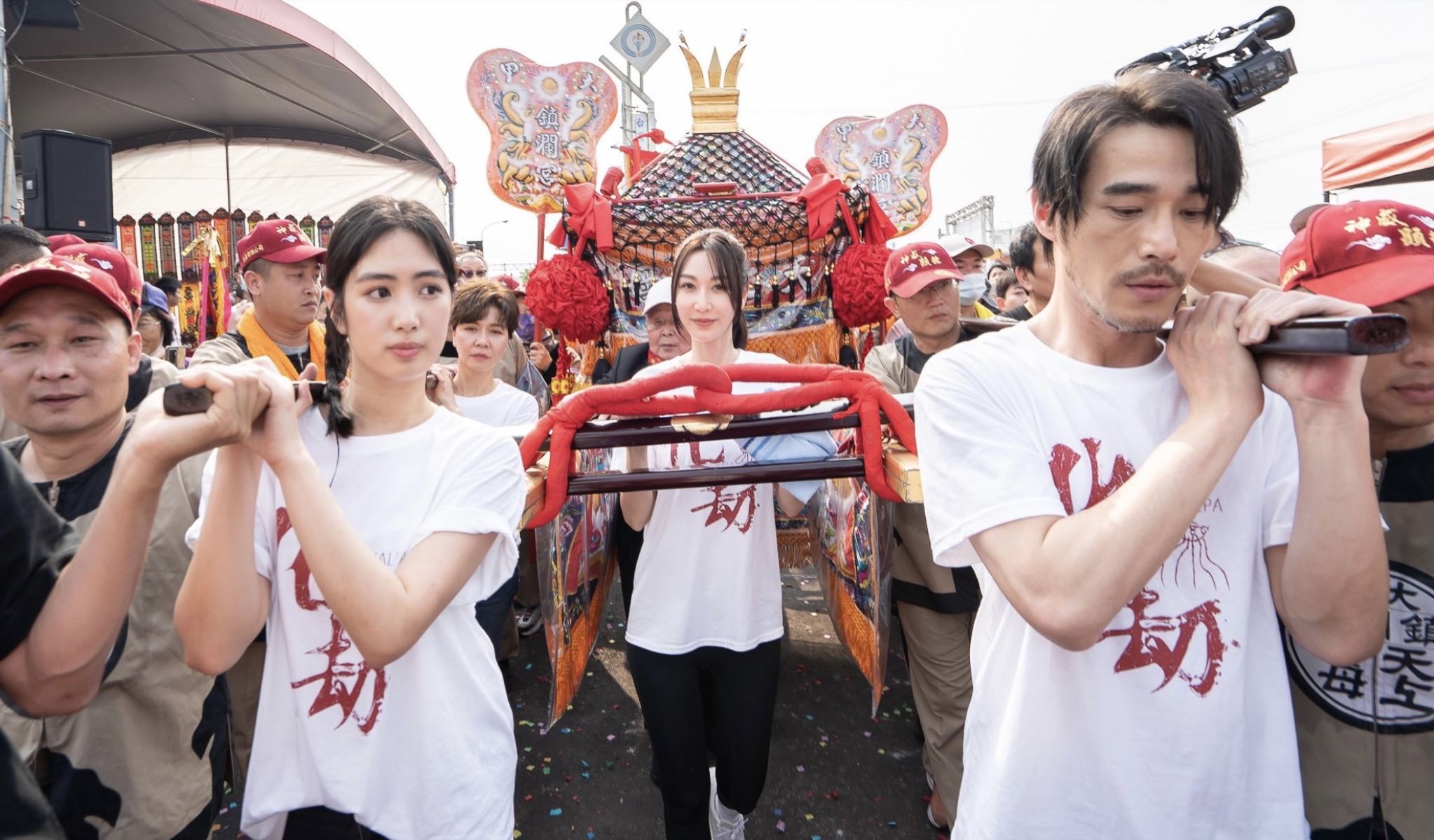 曾莞婷（中）、黃騰浩（右）、雷嘉汭（左）參與大甲媽祖遶境活動並抬轎。（台北双喜電影提供）