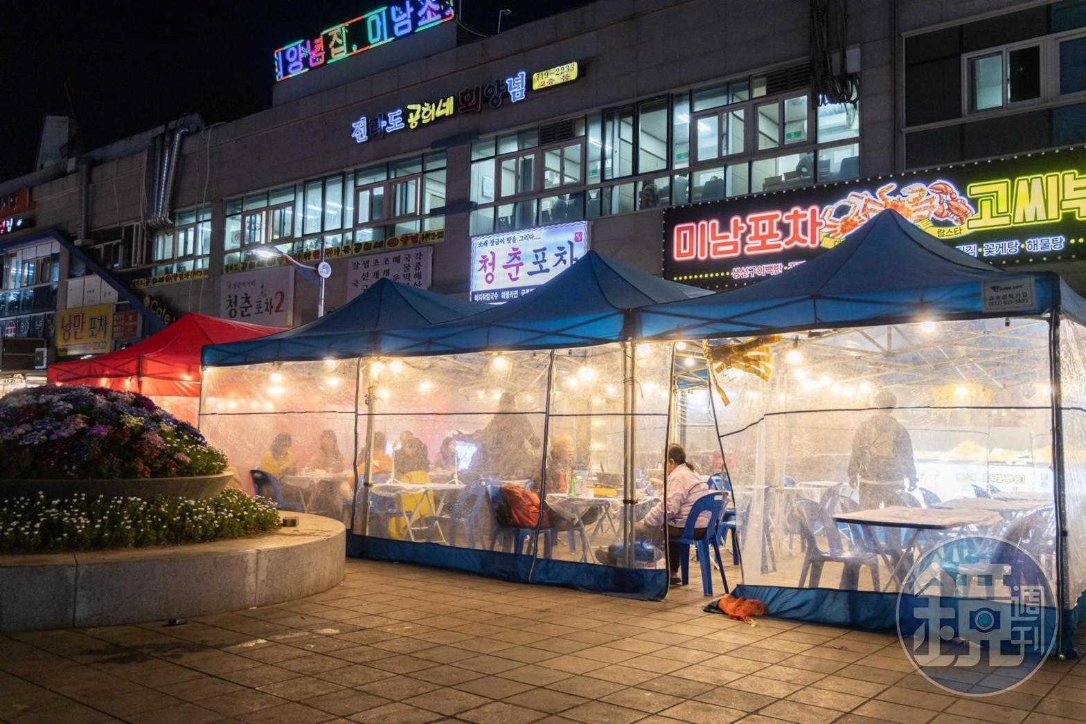 漁市場外圍被街頭小吃風格的布帳馬車環繞。