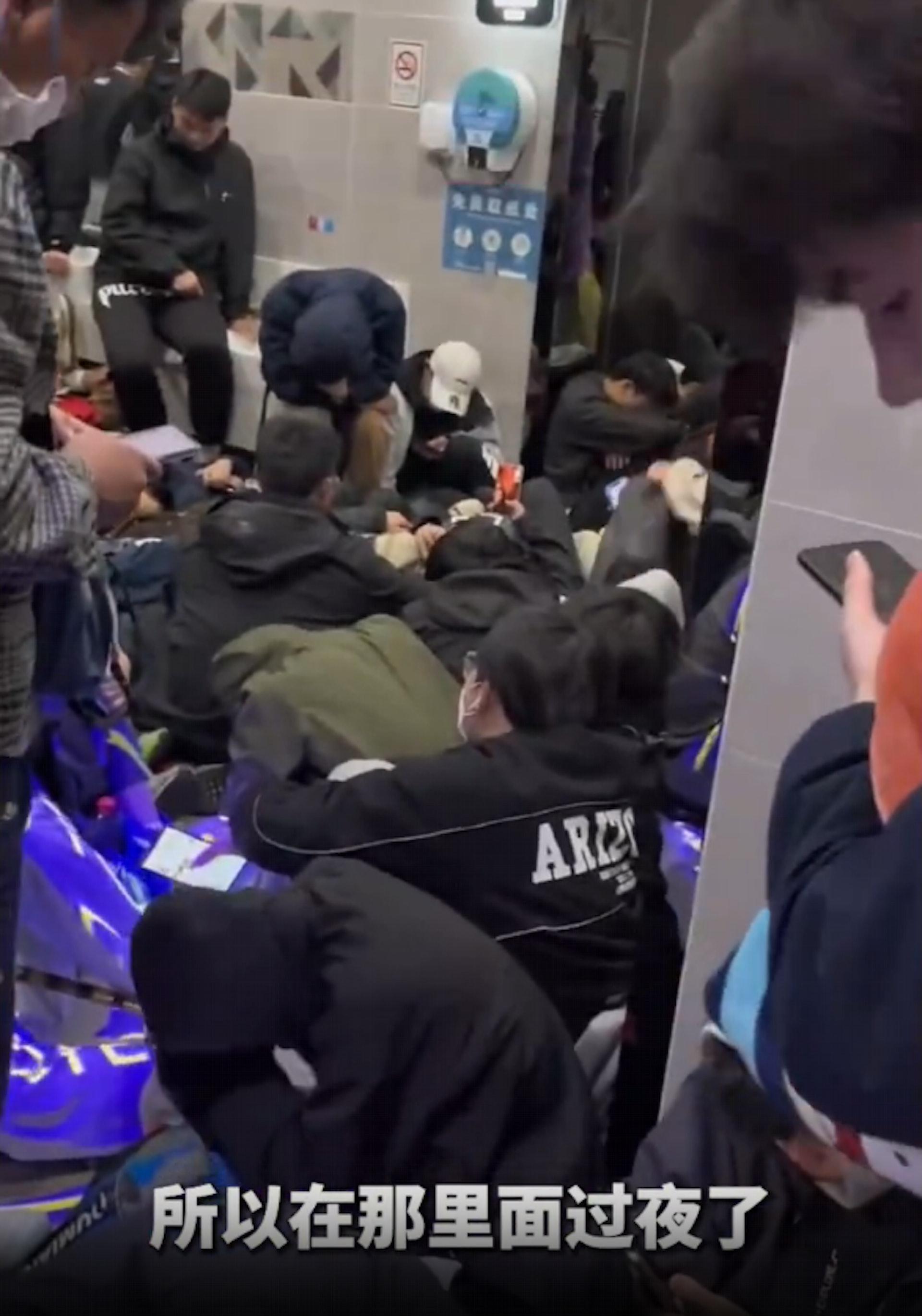 大批民眾直接睡在公廁的走道。（翻攝自微博）