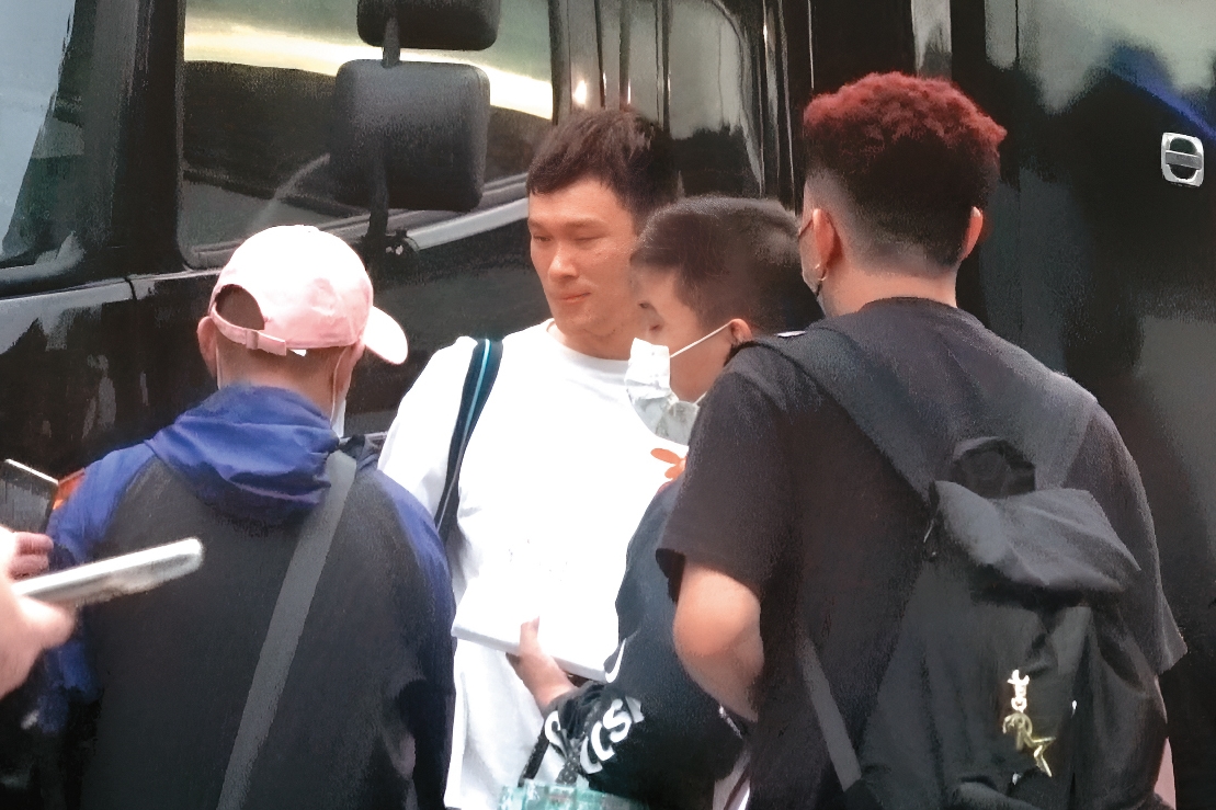 18：06 球賽結束後，胡凱翔（左二）從球員通道走出，遇到幾位球迷向他討簽名。