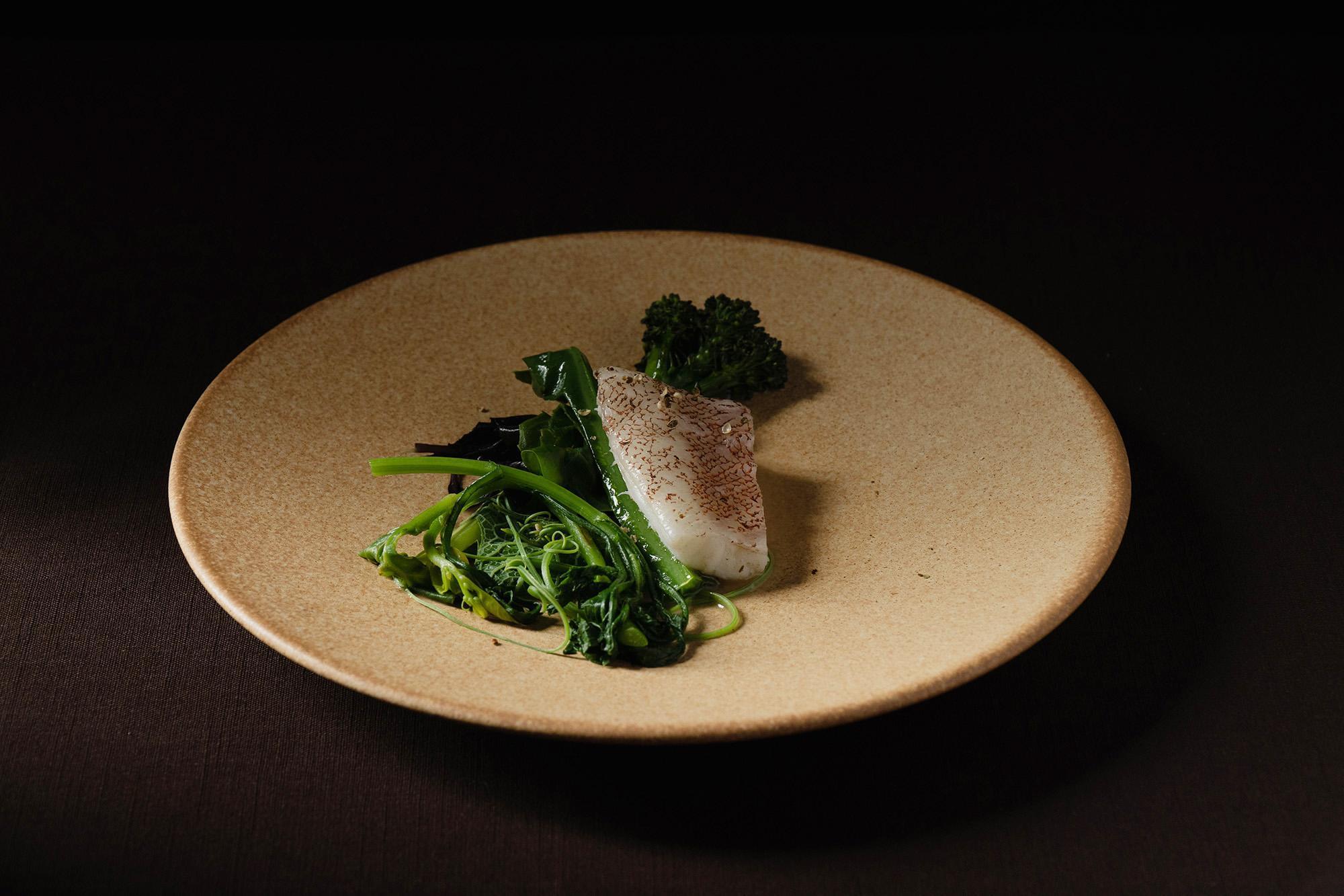 「蒸石斑魚、蒸餾濃縮魚湯、野菜、刺蔥籽」將熟成石斑魚，以無花果葉包覆去蒸，呈現青草香。（樂埔薈所提供）