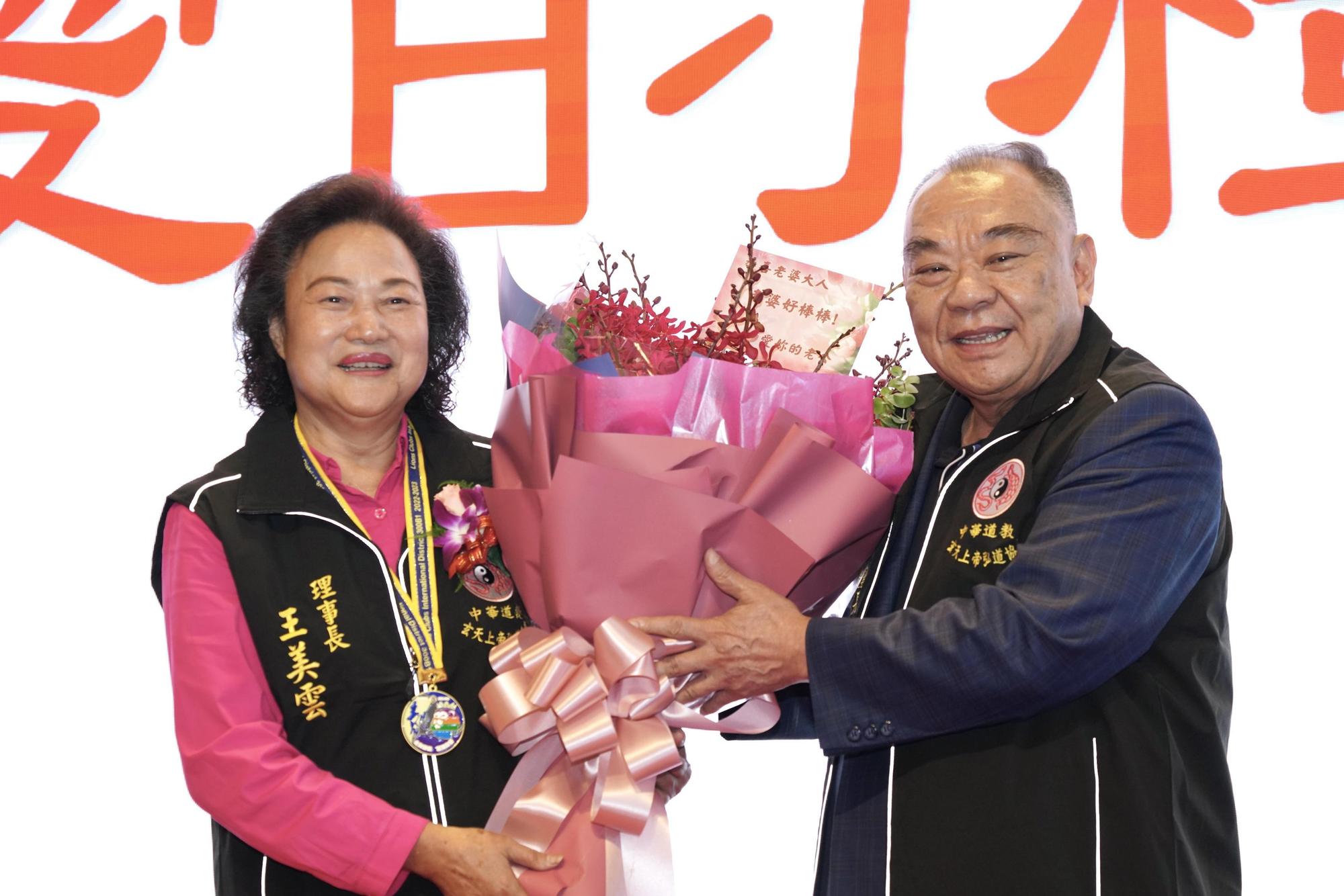 麗寶集團董事長夫人王美雲（左）接任中華道教玄天上帝弘道協會理事長，麗寶集團董事長吳寶田現身獻花。（麗寶集團提供）