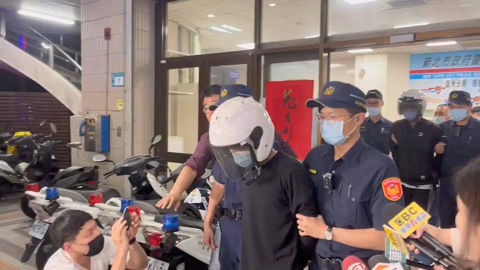 姚男（白色安全帽者）涉嫌槍殺張姓男子，今日遭新北地檢署起訴。圖為姚男5月間遭移送畫面。（警方提供）