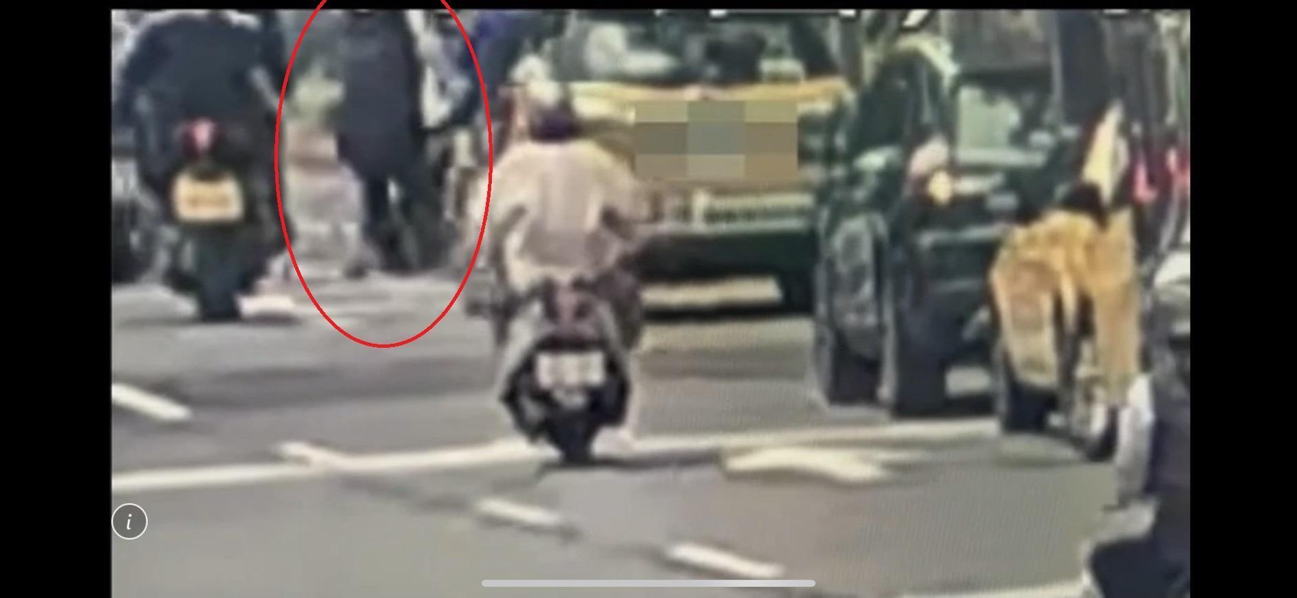 計程車司機（紅圈處）趁停等紅燈機會，下車拉扯男大生的背包理論。（翻攝畫面）