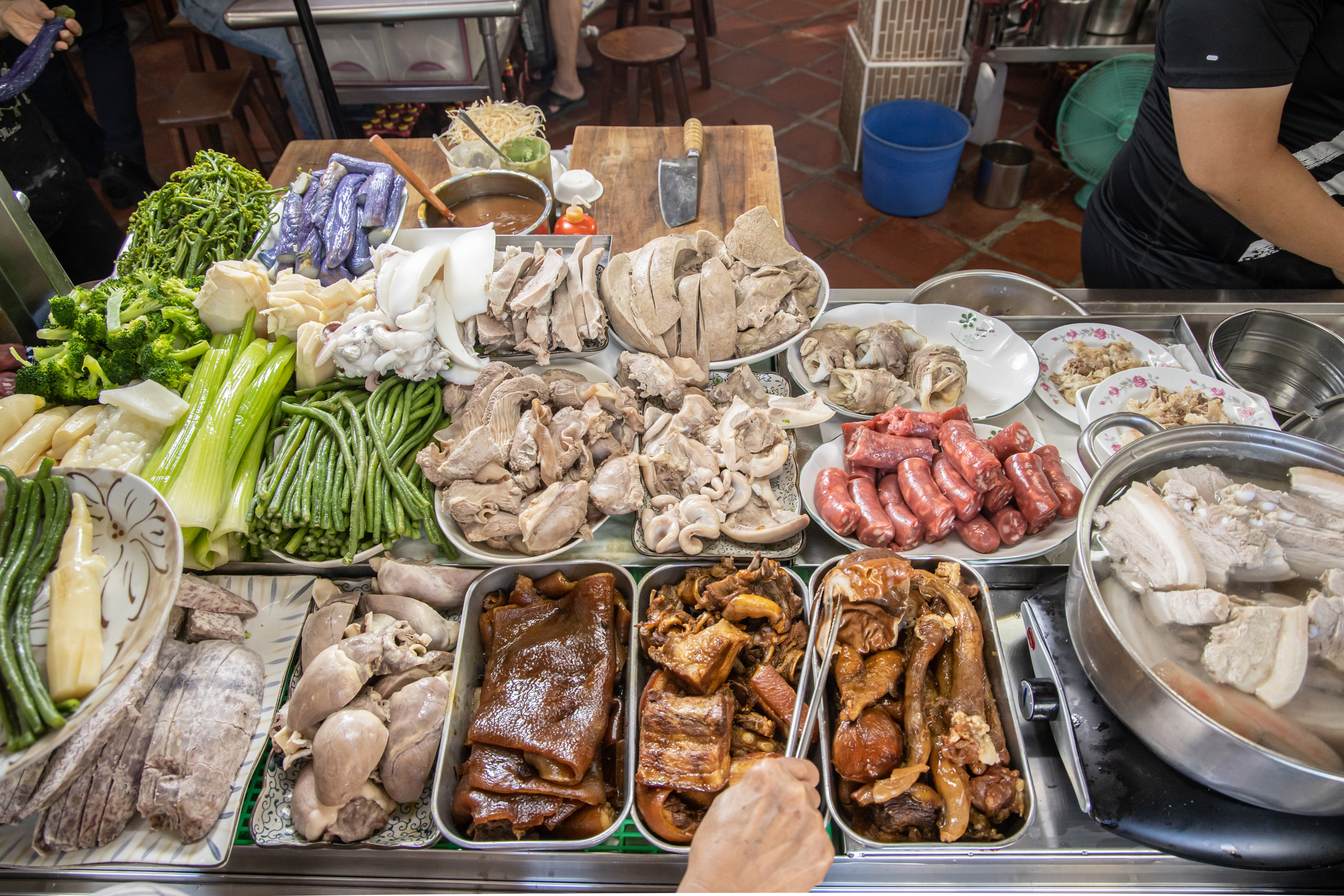 餐檯上擺滿各式肉品、豬內臟和蔬菜，選擇非常多樣，而且都是親民銅板價。