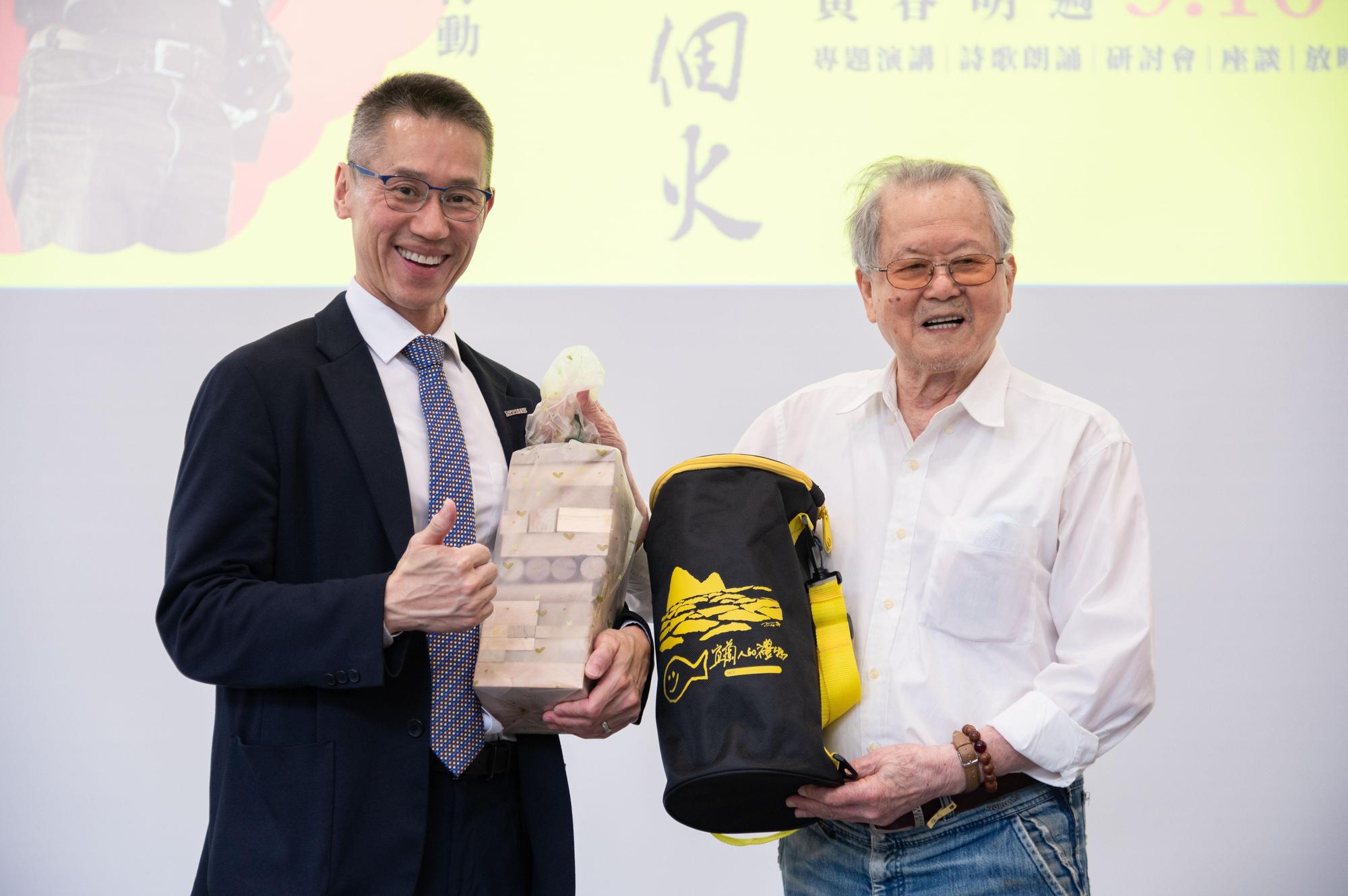 黃春明(右)送了一套用漂流木做的積木給清華大學校長高為元。(清華大學提供)
